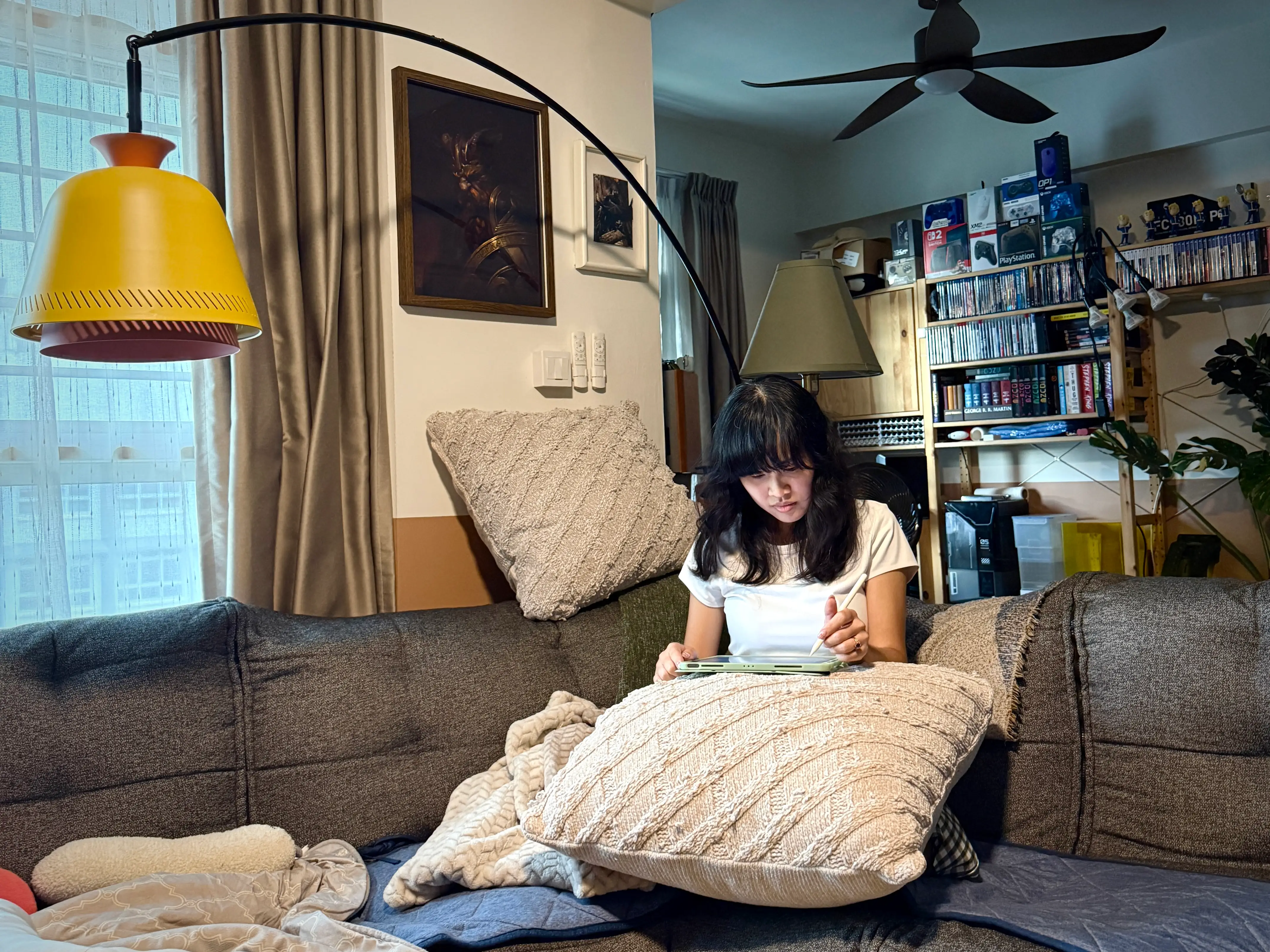 Trisha Soo working on digital illustrations on her iPad in her living room in Singapore.