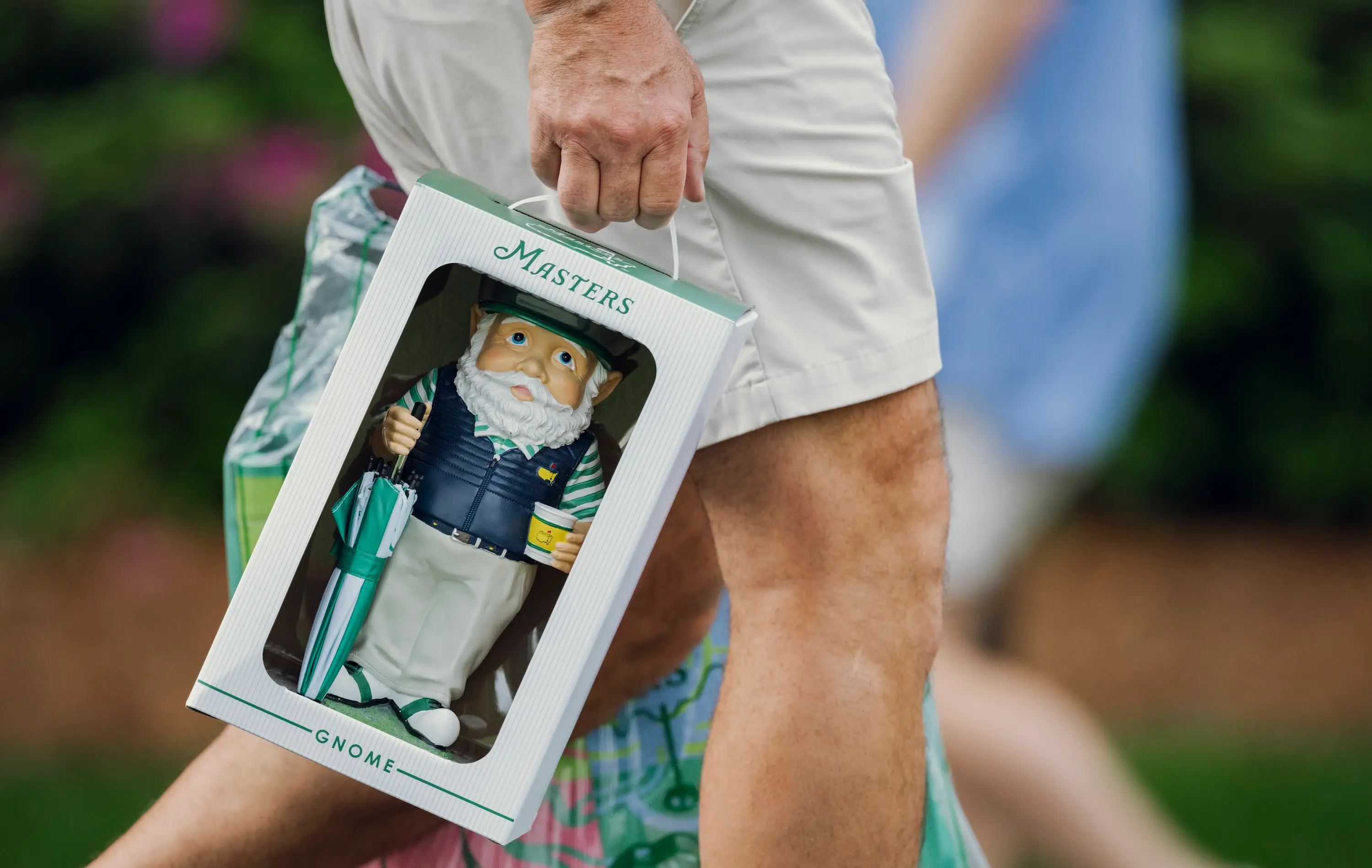 A Masters Tournament attendee carries a gnome, one of the most popular merchandise items this year.