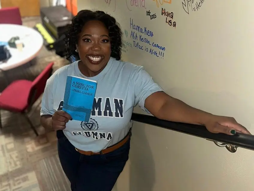 Qoman smiling with play book on stairs