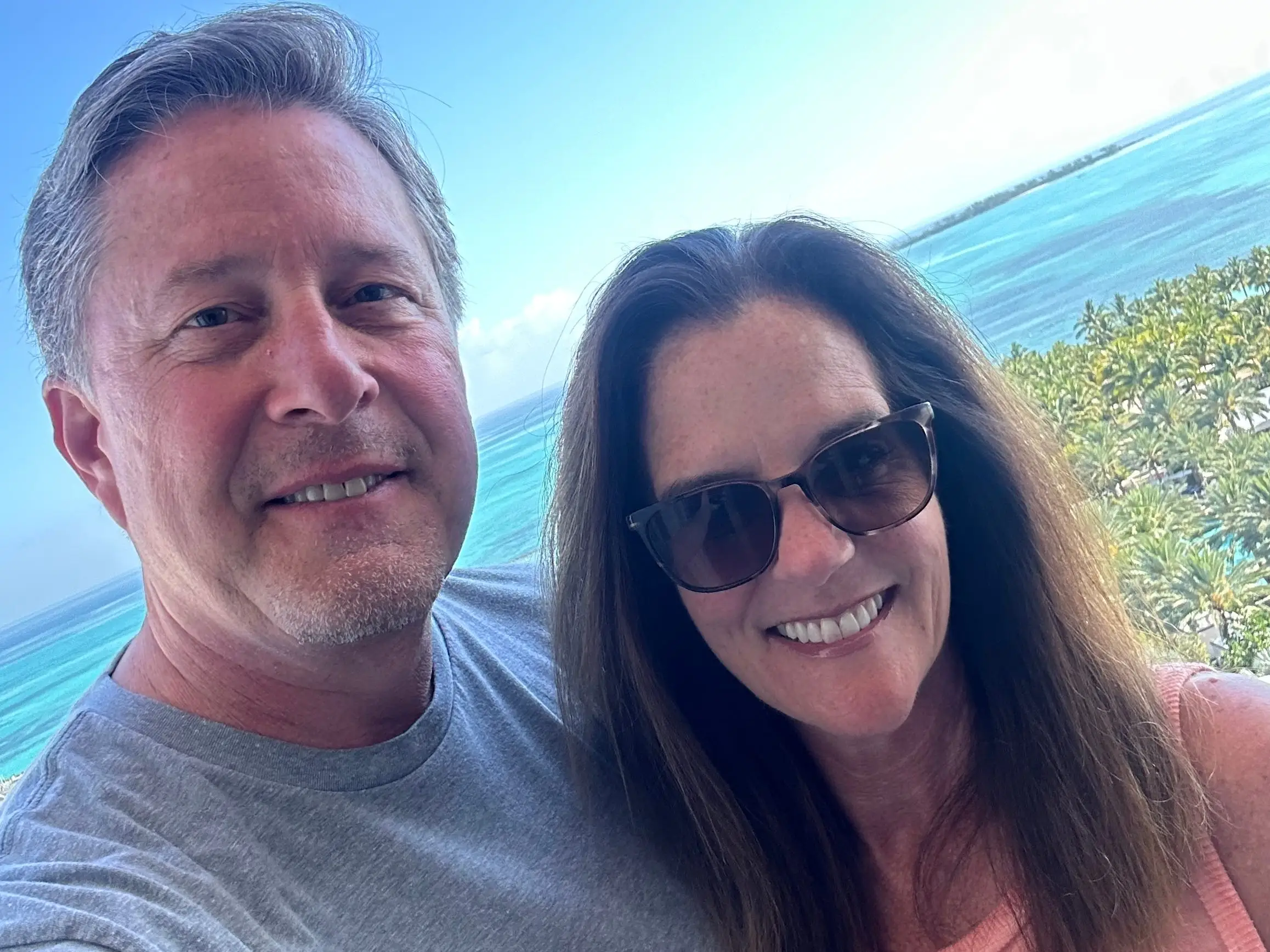 selfie of Christina Daves and her husband in front of the ocean