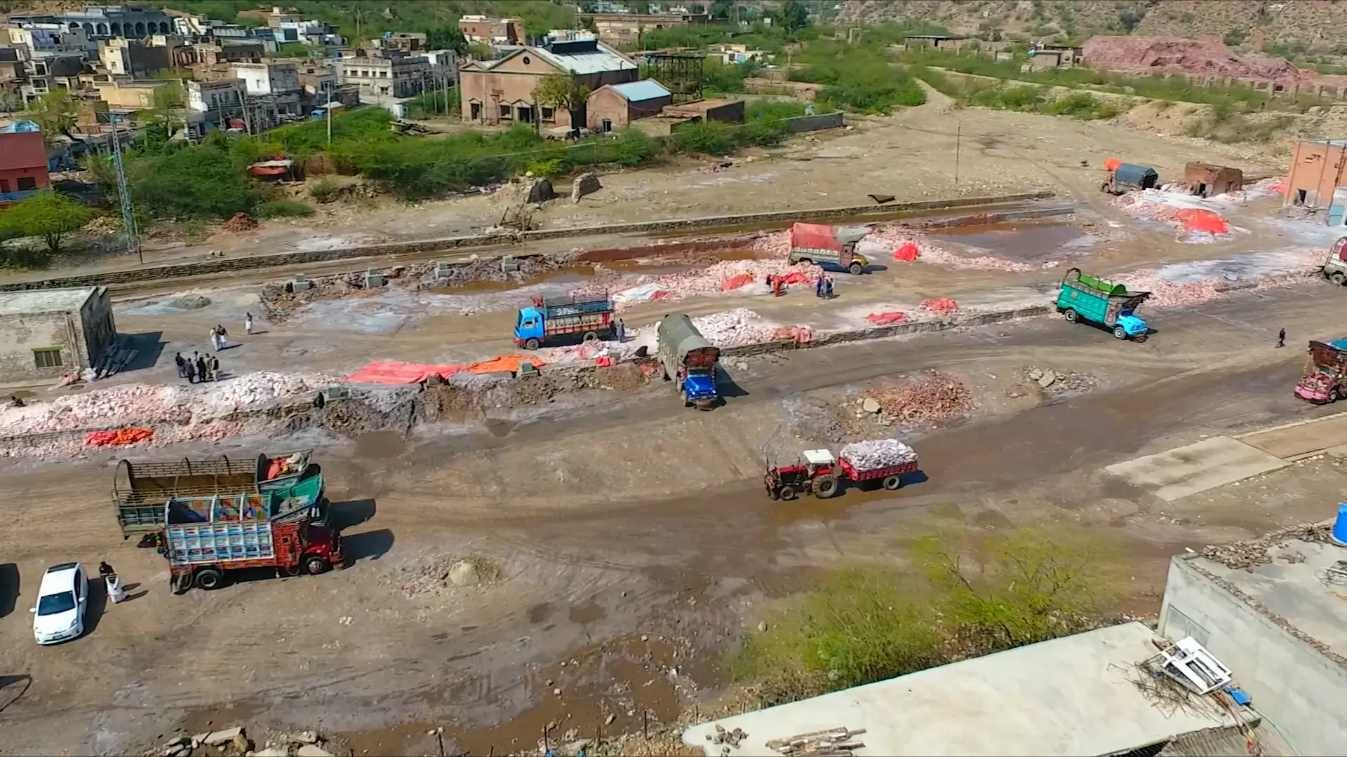 Trucks move large deposits of pink salt in Pakistan.
