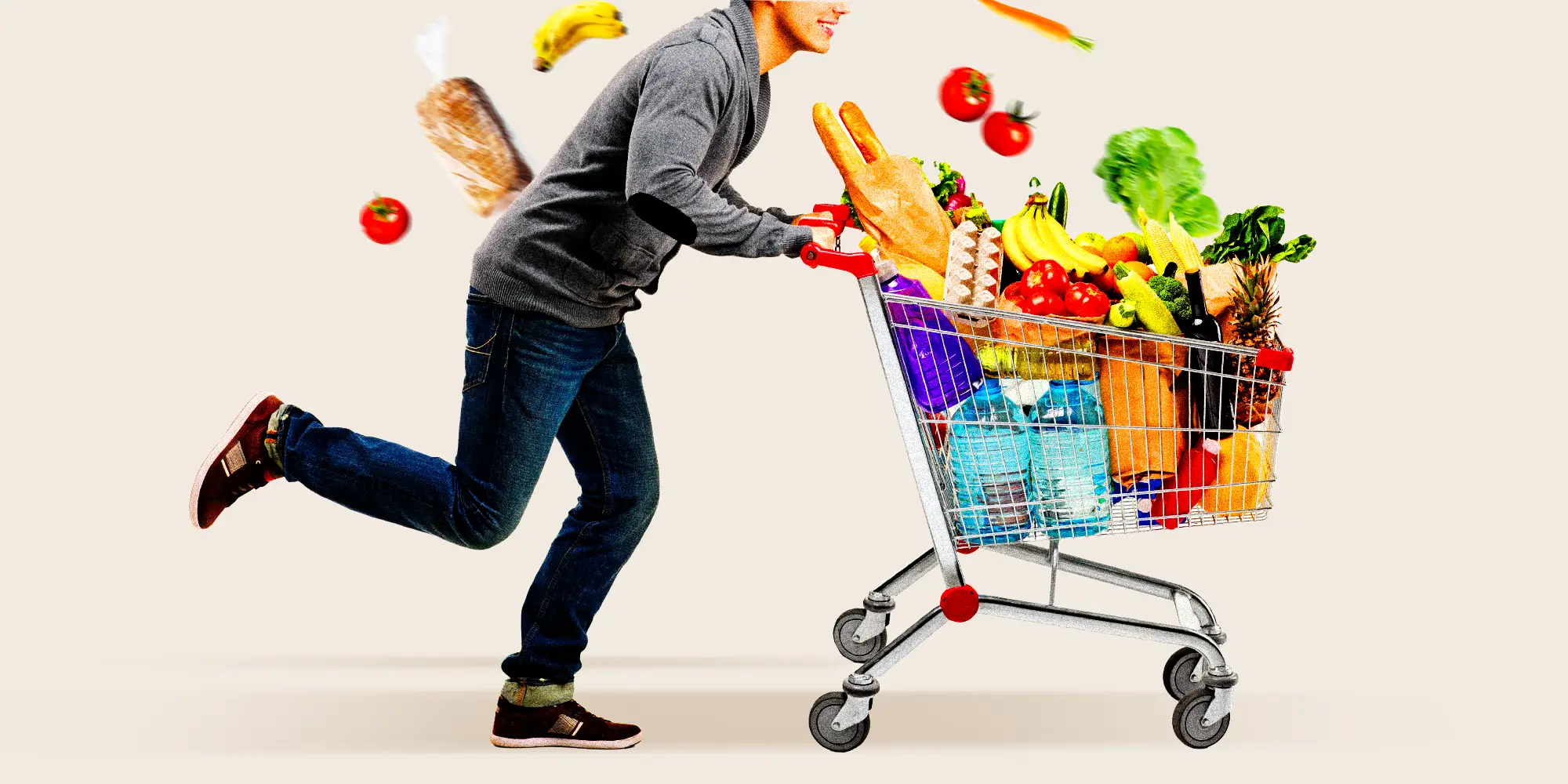 A man with a shopping cart full of groceries running