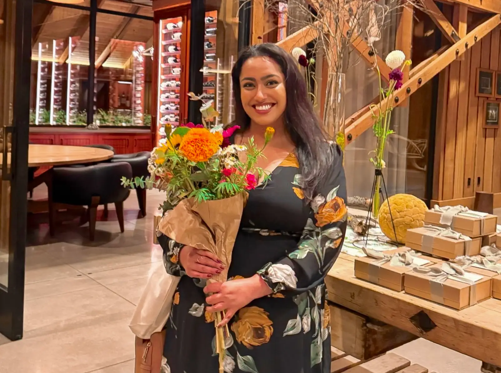 The writer holding a bouquet of flowers at an event.