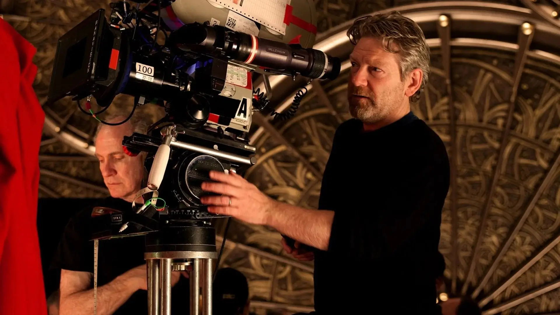 Kenneth Branagh looking into a camera viewfinder on the seet of Thor