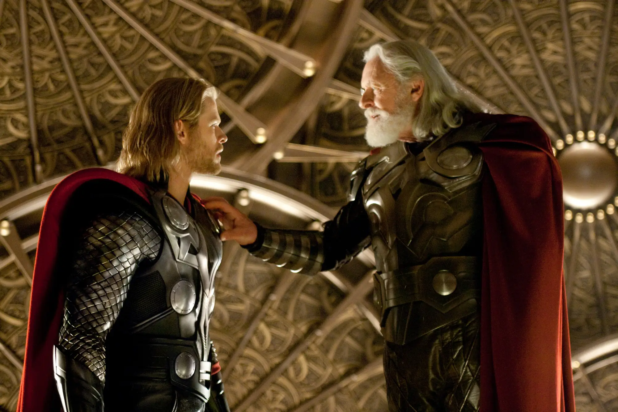 Anthony Hopkins putting his hand on Chris Hemsworth's shoulder in Thor movie