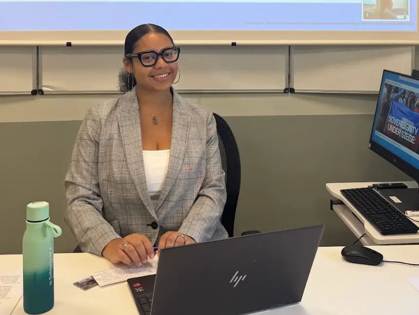 Nicolette Alexandra Brito-Cruz sitting in front of two computers