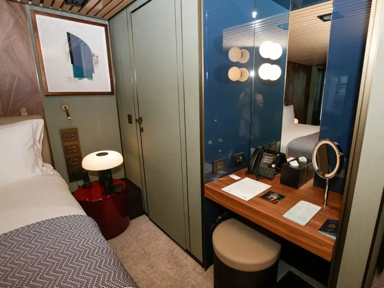 empty desk next to bed in the Haven Penthouse with Balcony on Norwegian Aqua