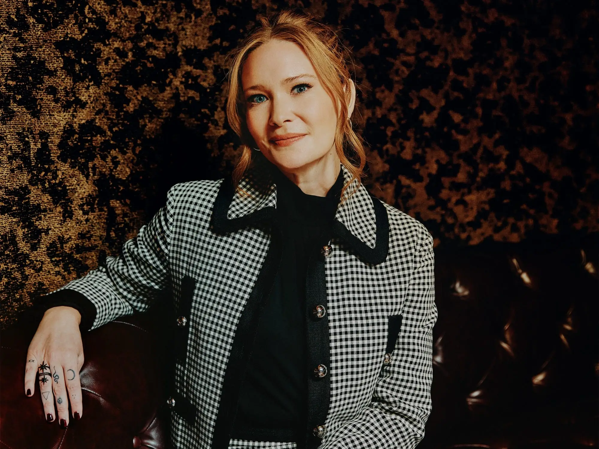 A headshot of Sarah J. Maas in front of a printed wallpaper.