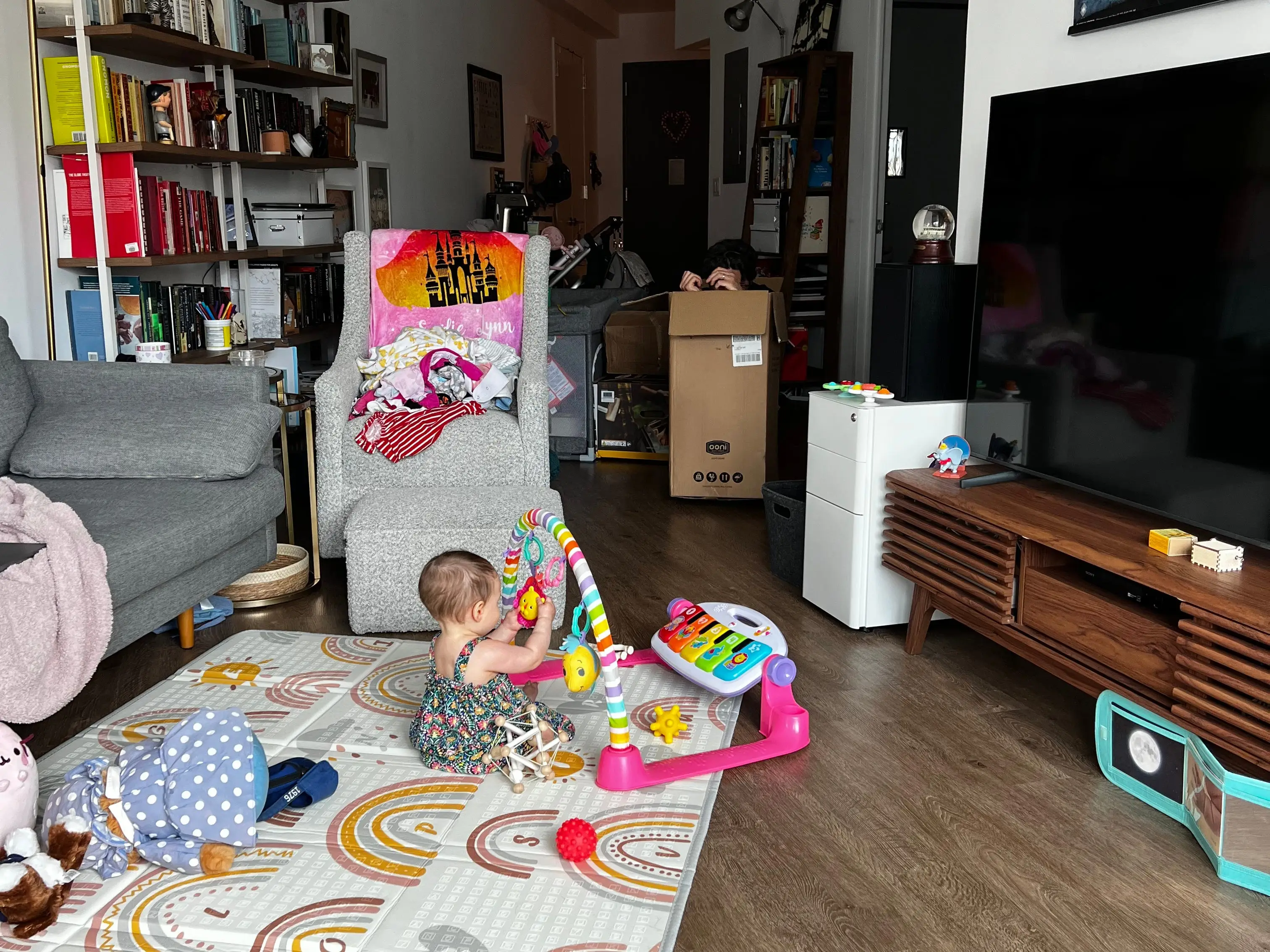 baby on play mat in front of tv