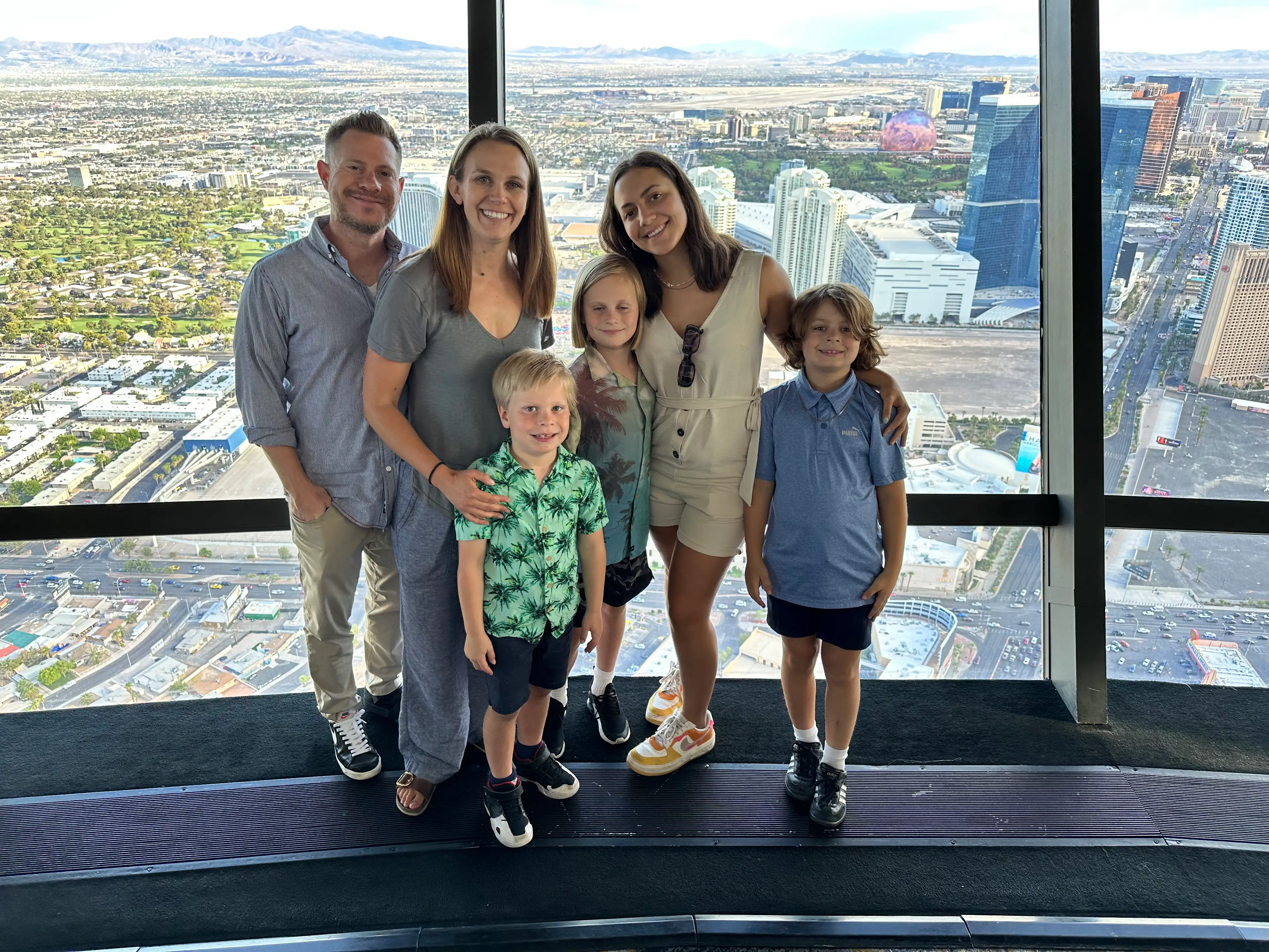 Three adults and three children against a city landscape