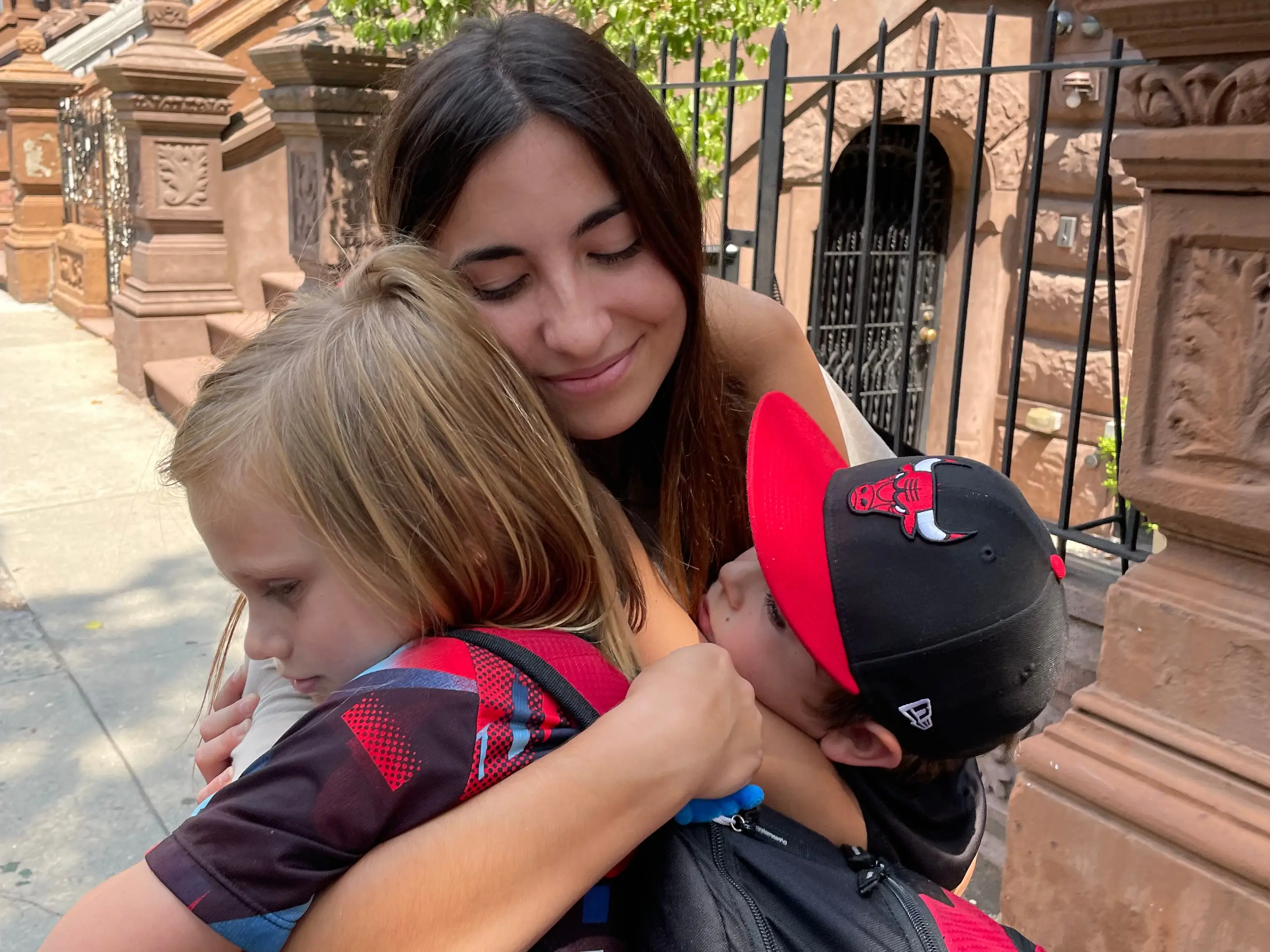 A woman hugging two young boys