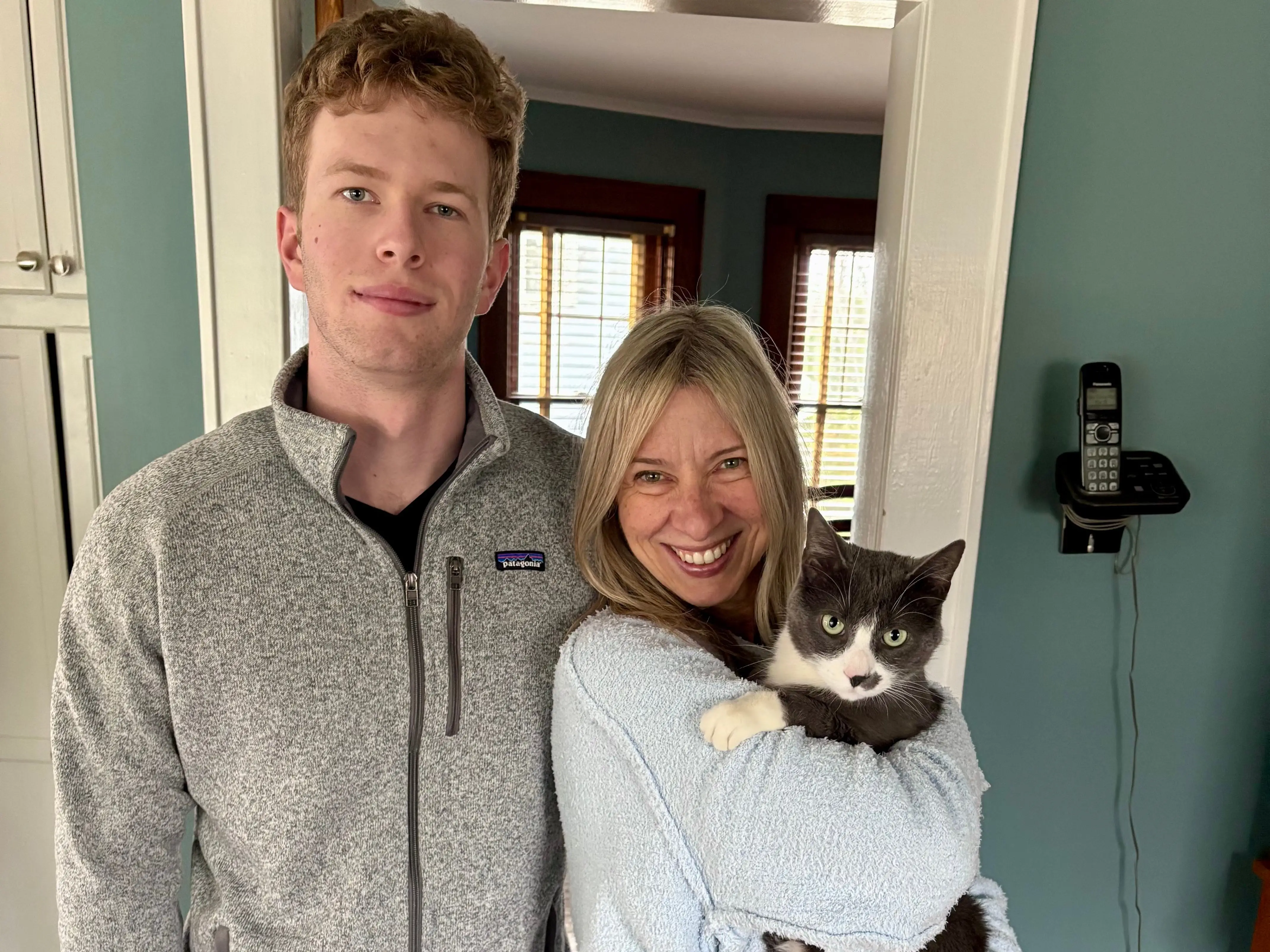 The author poses with her son and a cat.