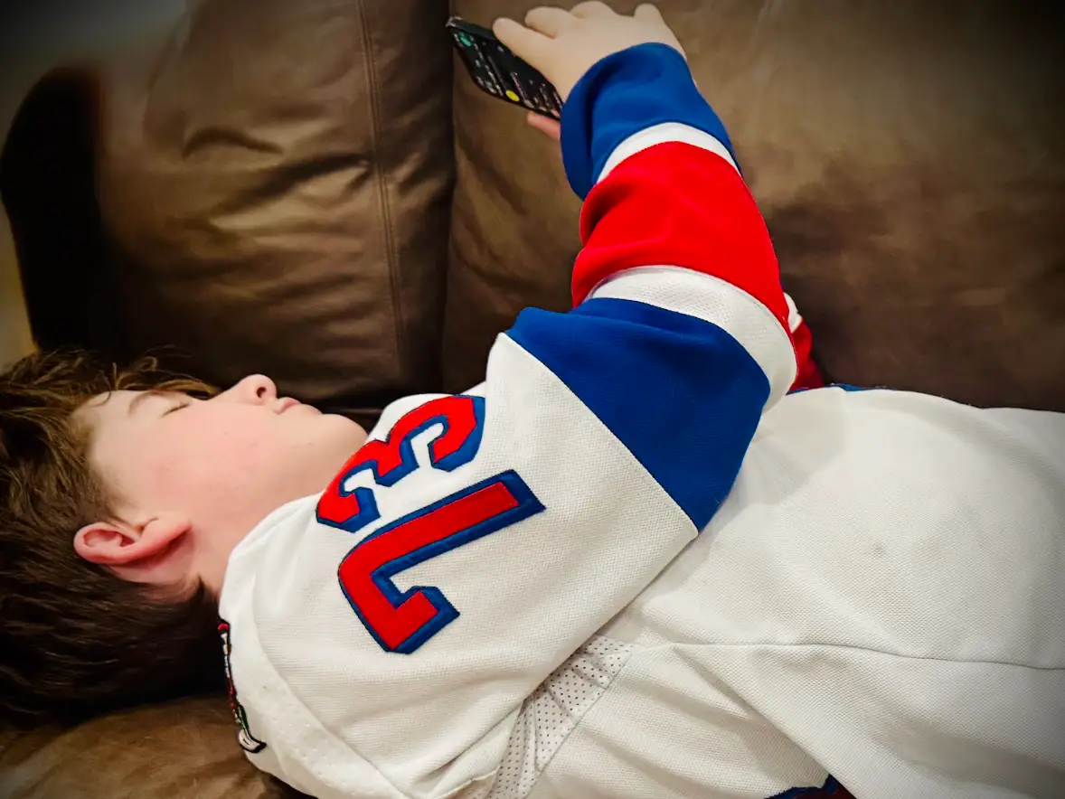 author's son on the couch with his cellphone