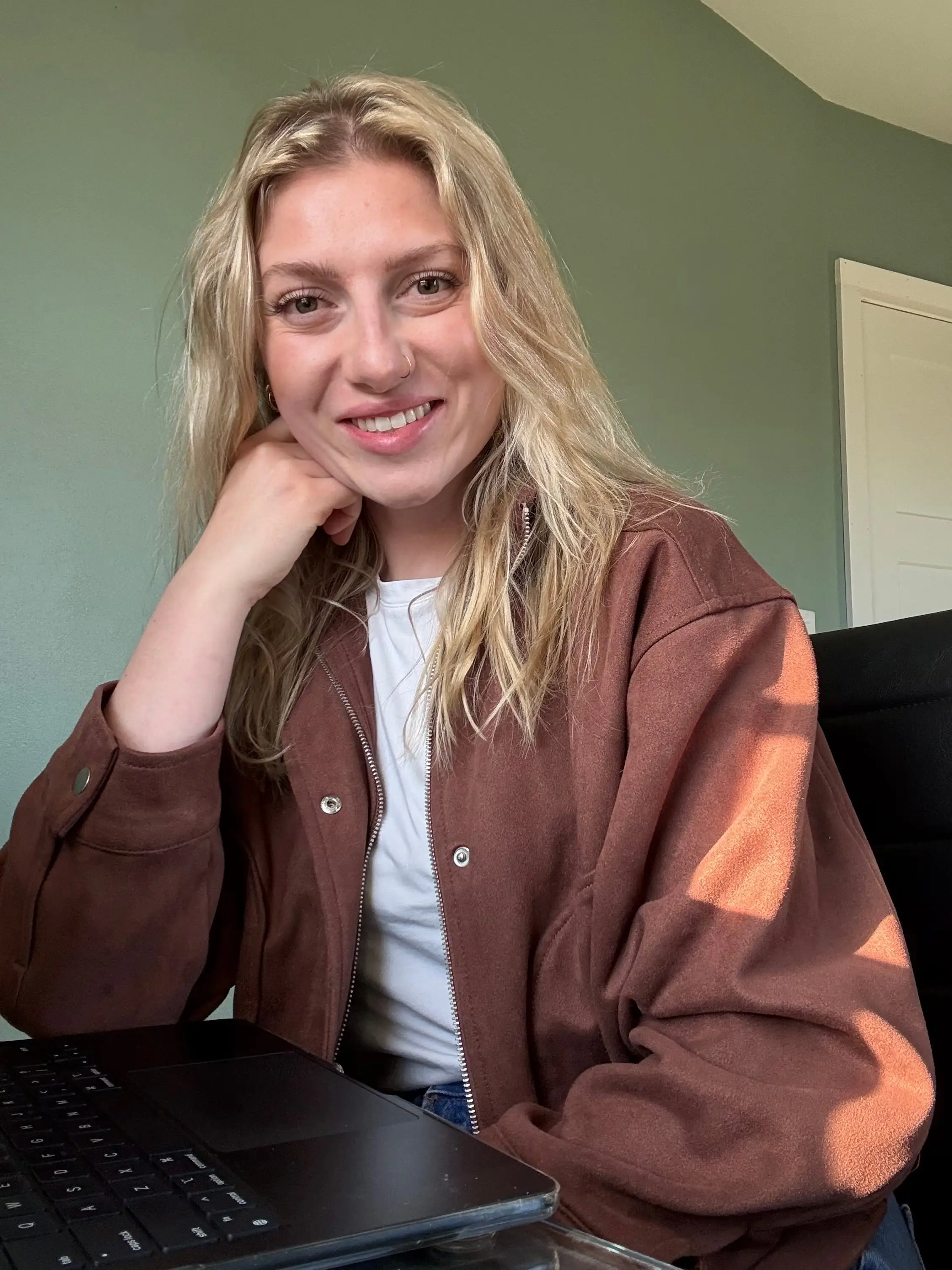 A woman is sitting in front of a computer on a desk.