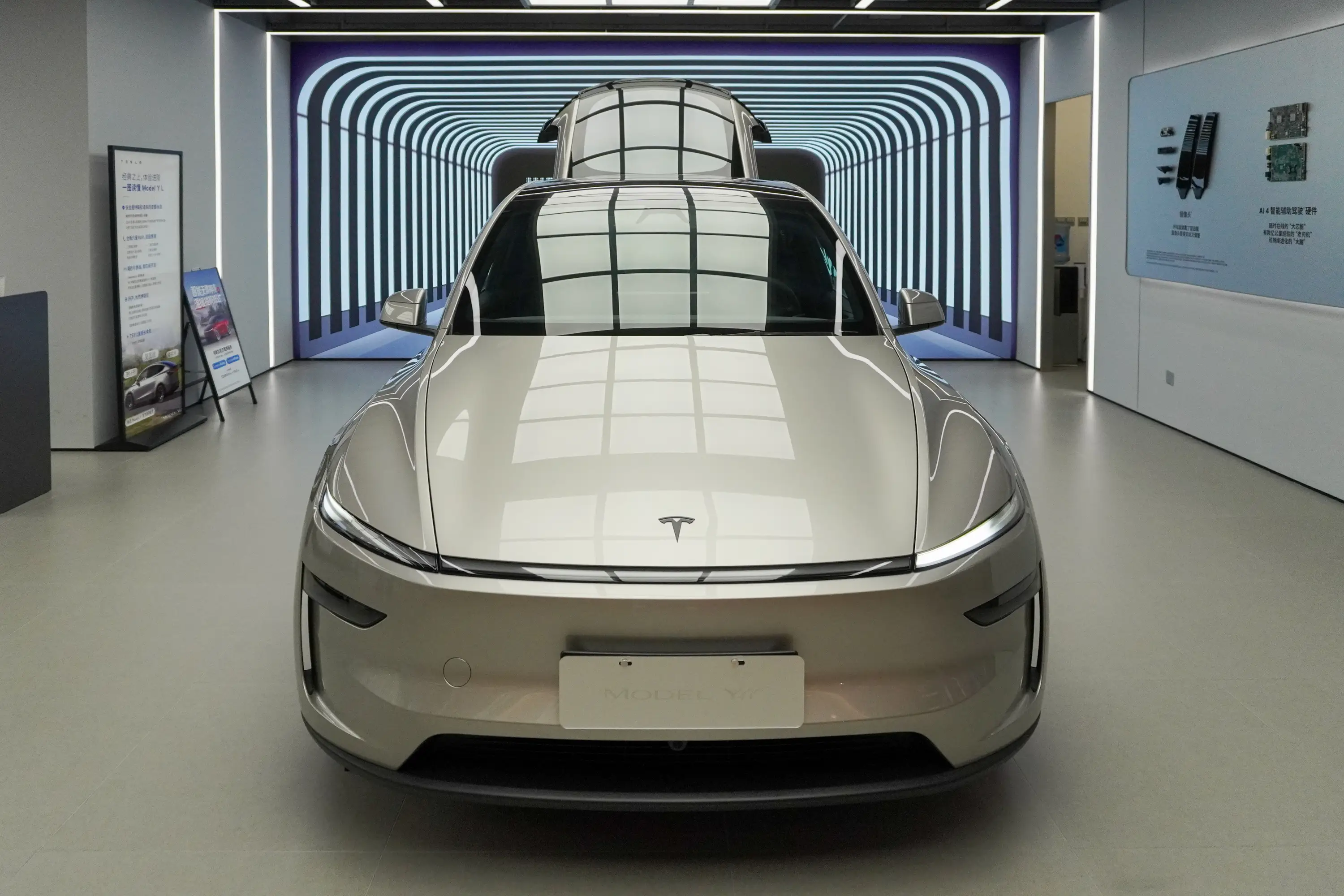 A front view of a Tesla Model Y with its doors open positioned in a futuristic tunnel-style seen displayed inside the Global Harbor store.