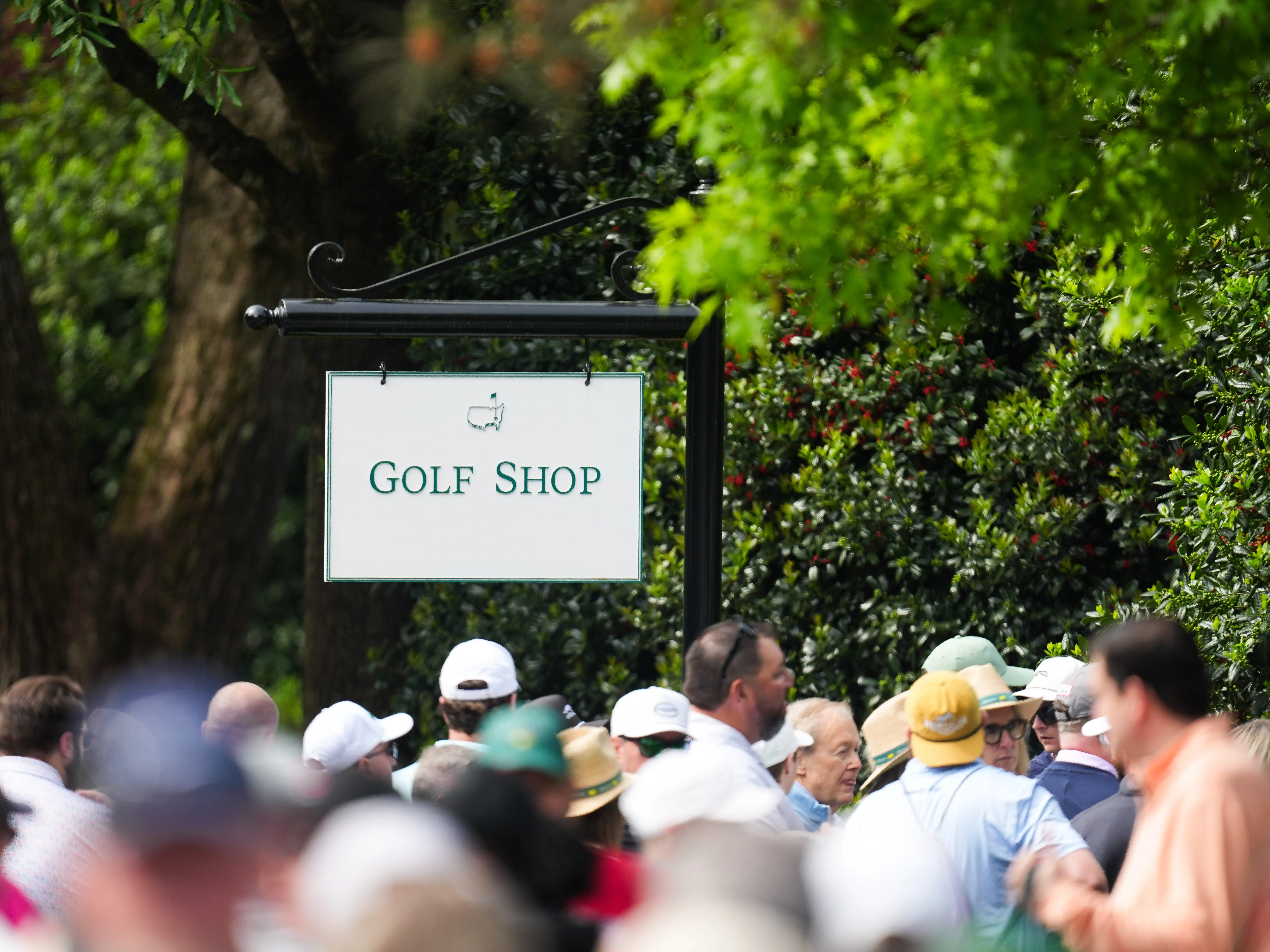 A sign over a crowd of Masters patrons reading 