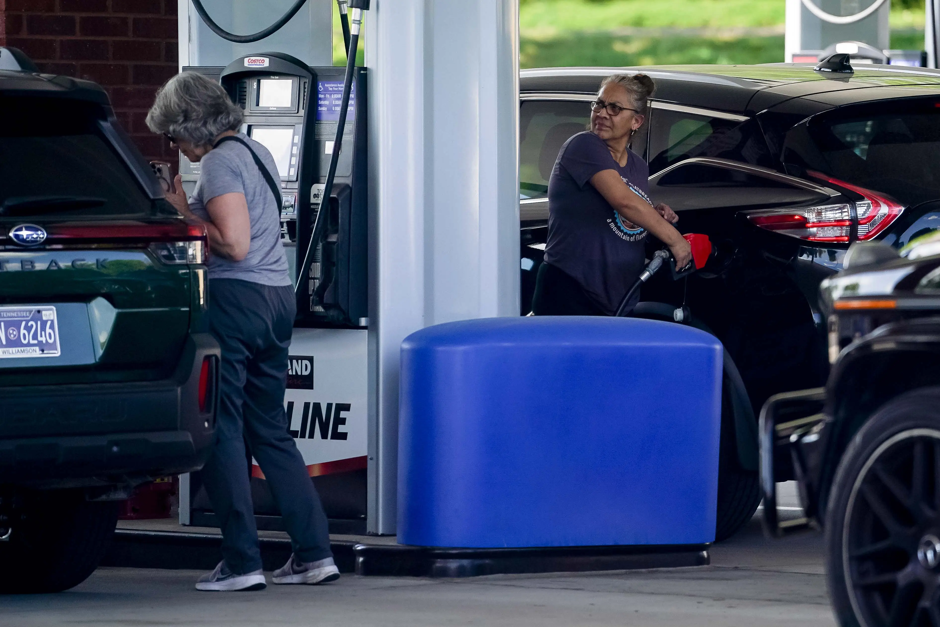 people fill up their cars with gas at a gas station in california