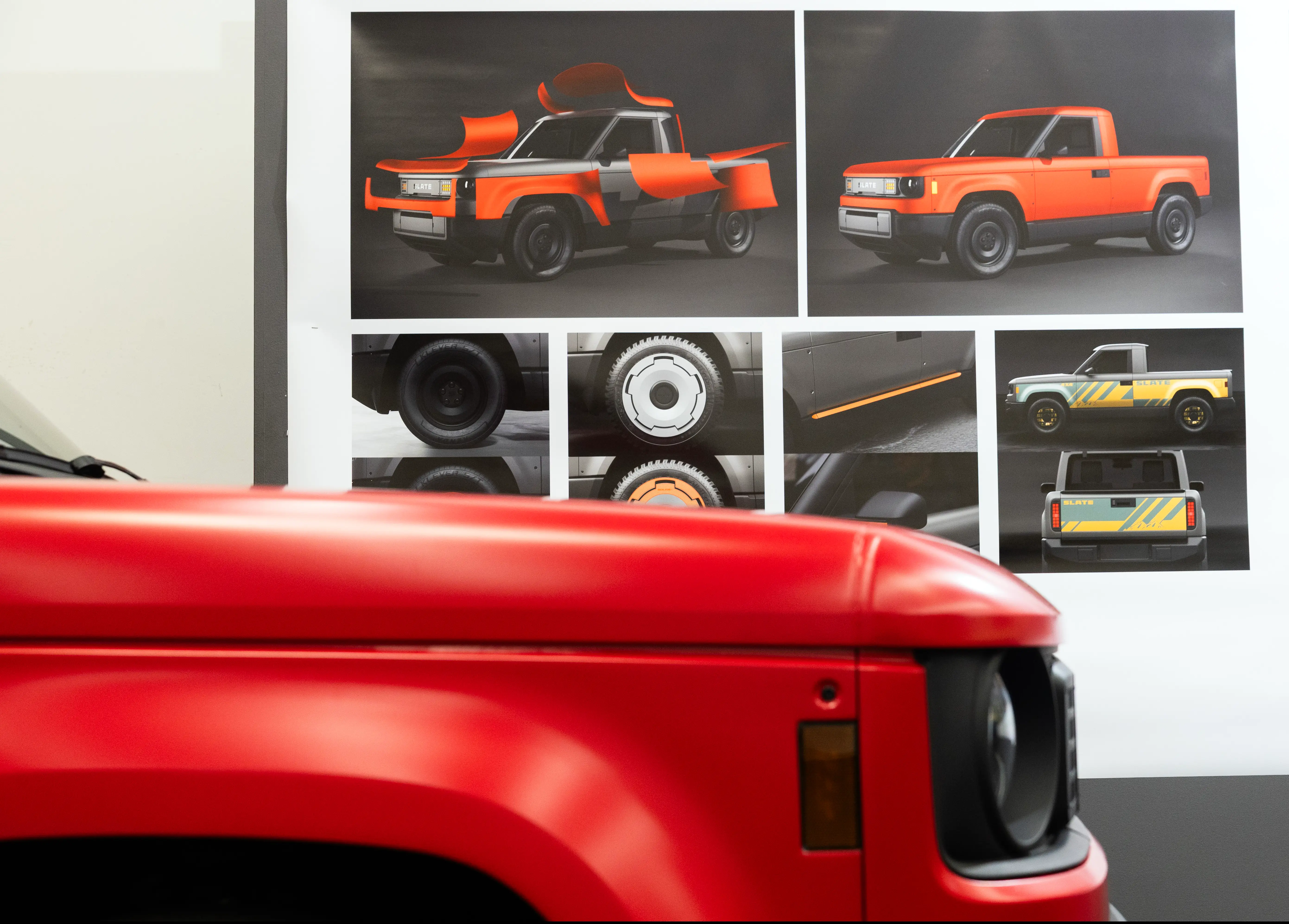 A red Slate truck stands in front of a visual board of other Slate designs.