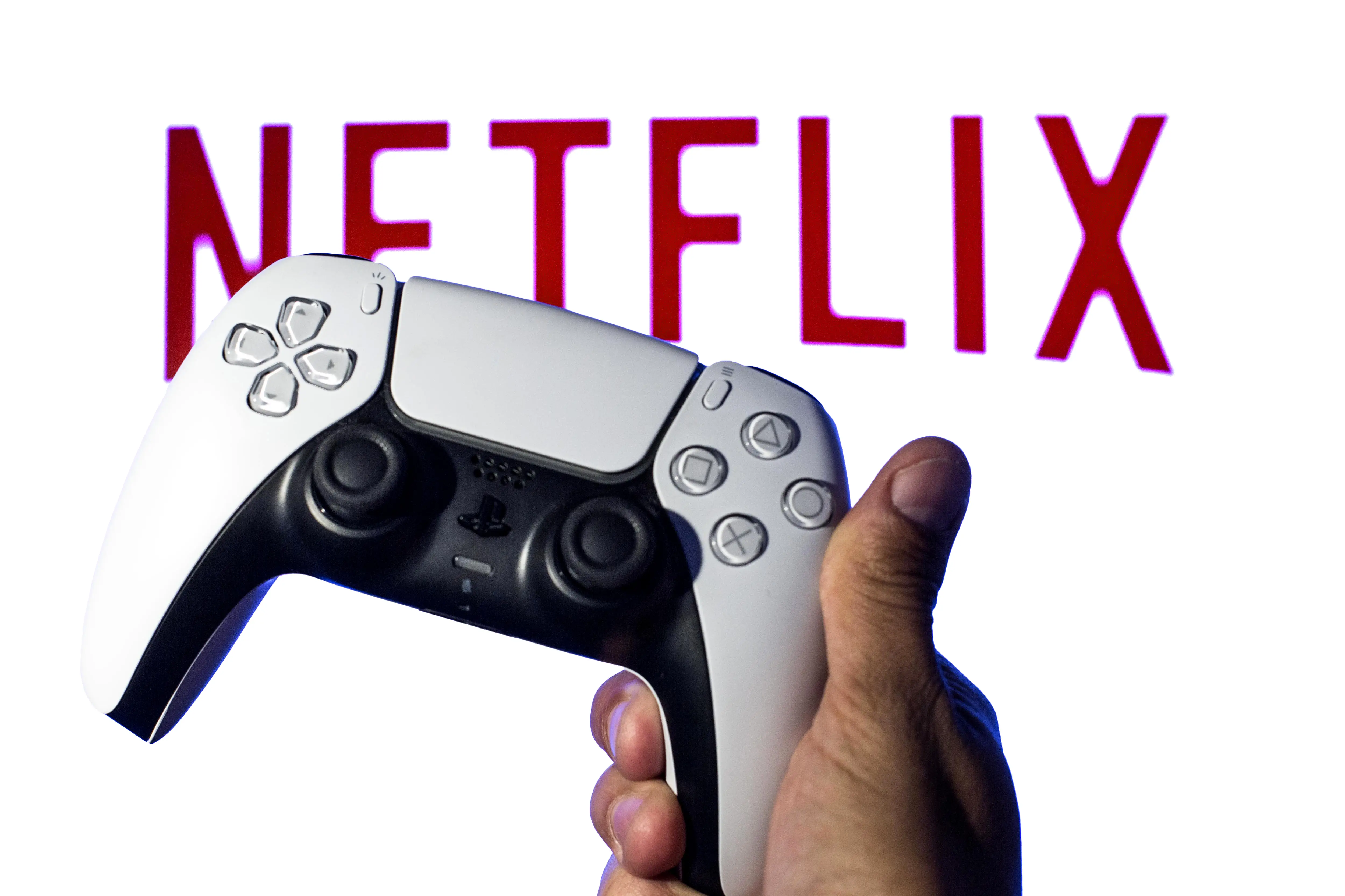 A game controller is pictured in front of the Netflix logo.