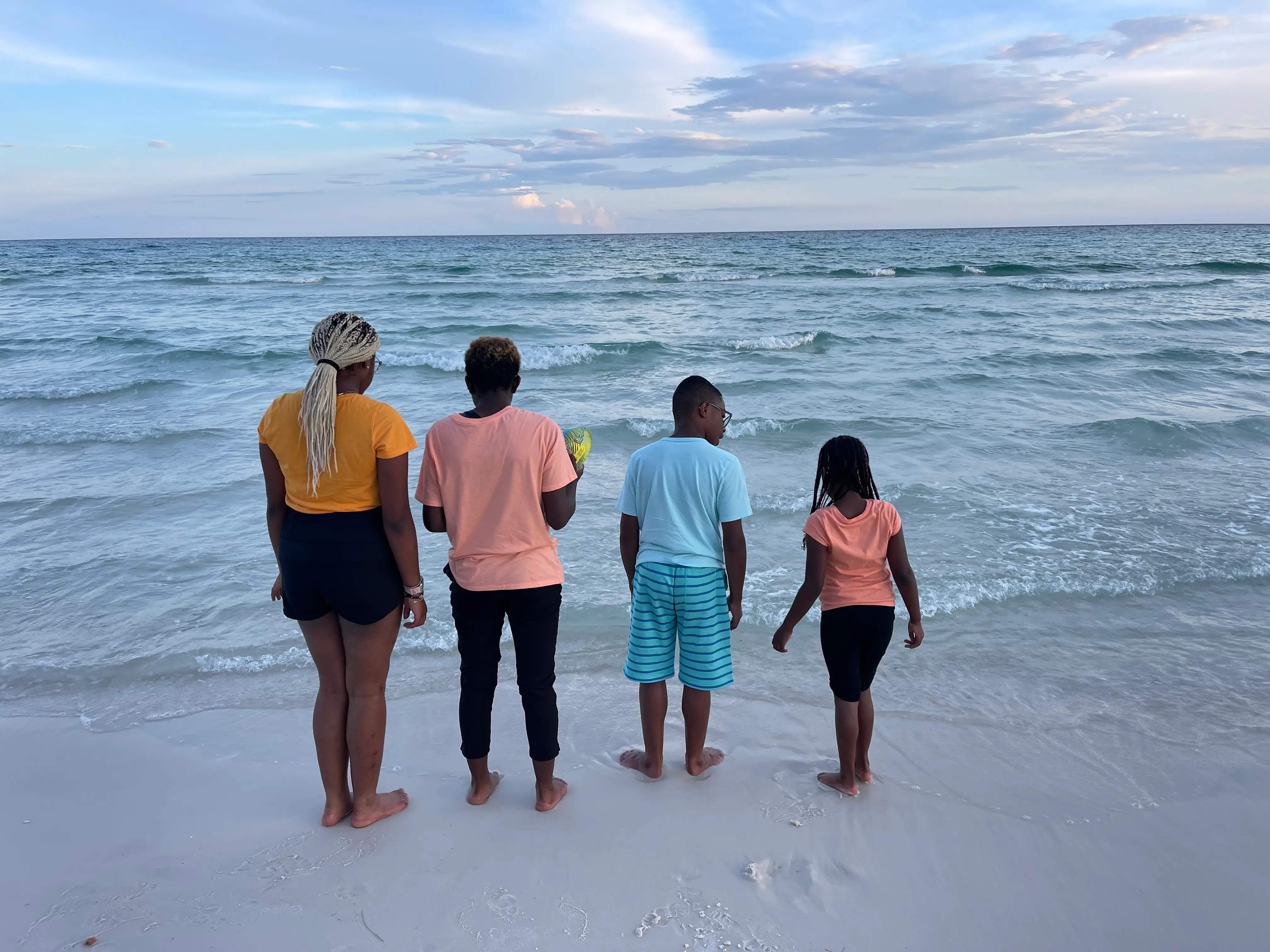 The author's four children stand at the shoreline at the beach.