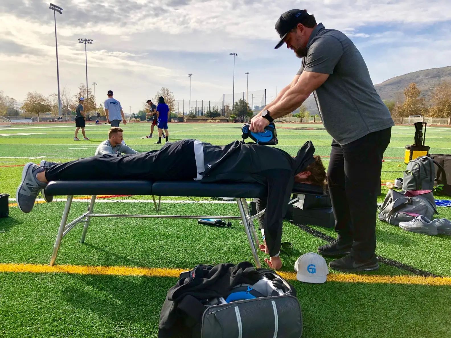 Dr. Jason Wersland using Theragun on athlete
