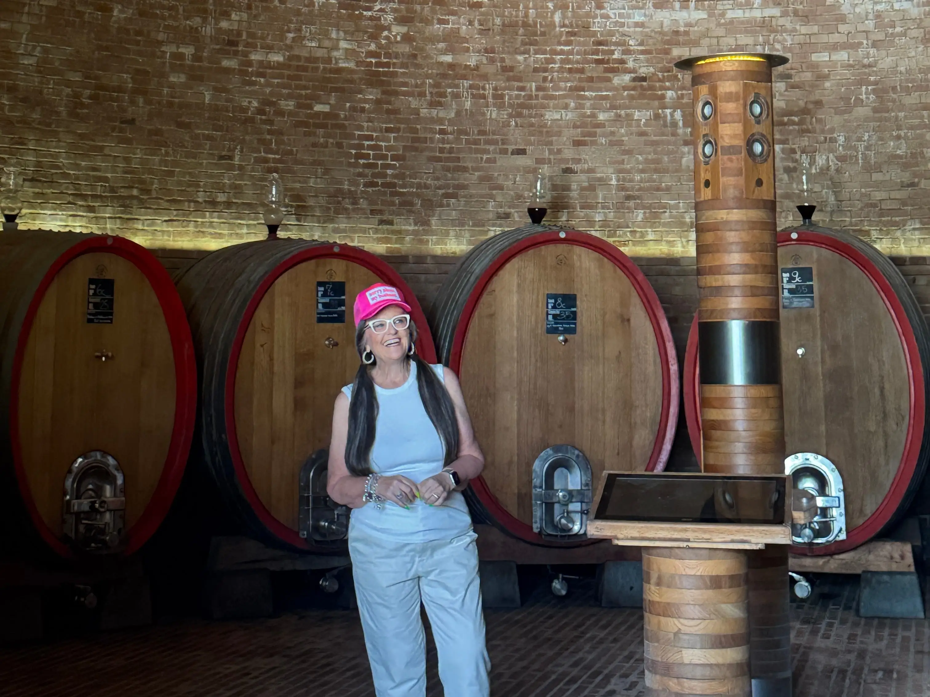 A woman standing near barrels of olive oil in Tuscany, Italy.