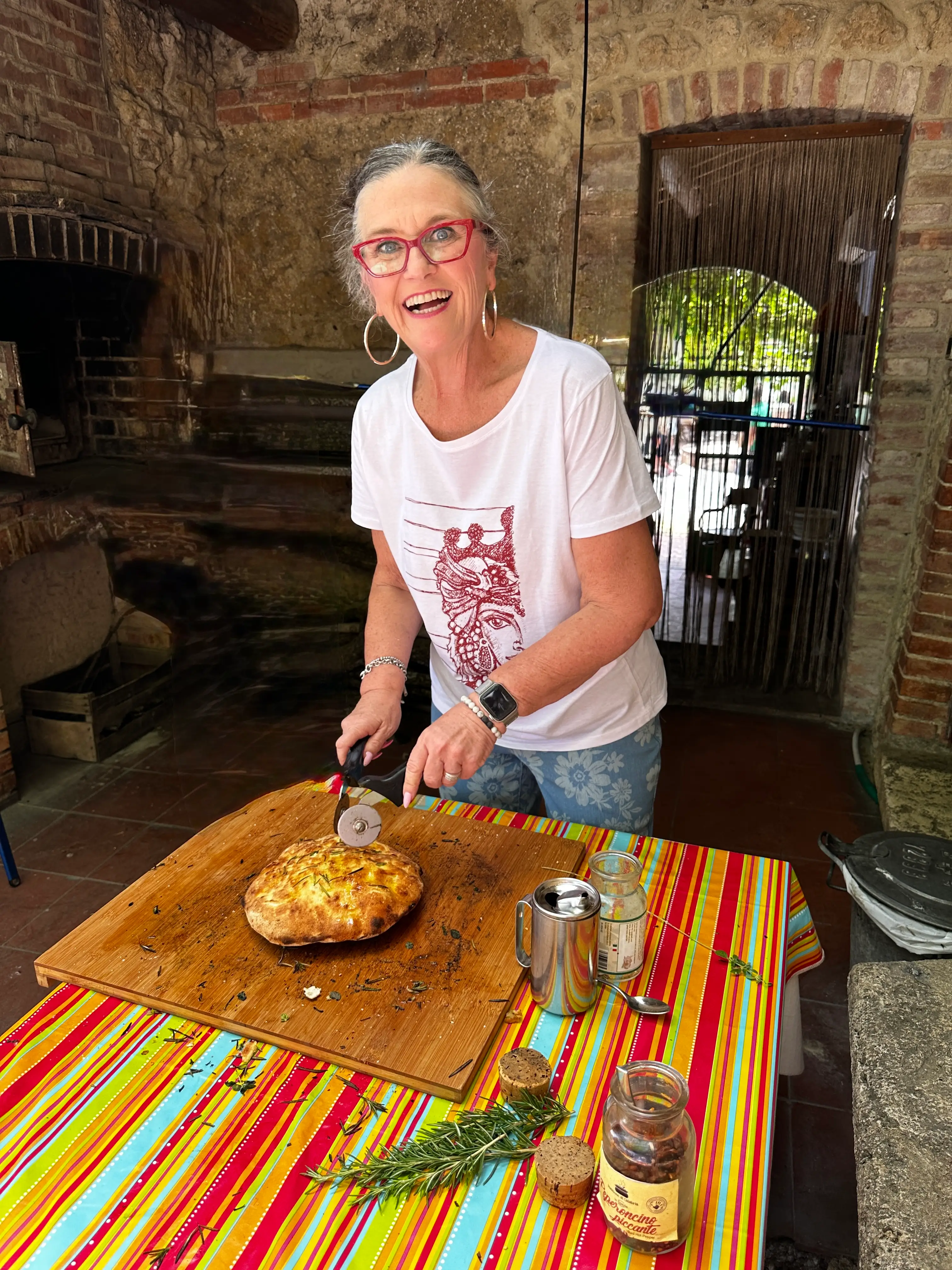 A woman cutting bread in a kitchen in Tuscany, Italy.
