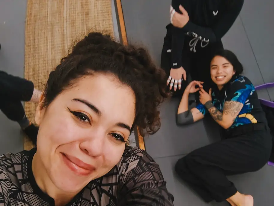 The writer taking a selfie with two friends at the Brazilian jiu-jitsu gym.