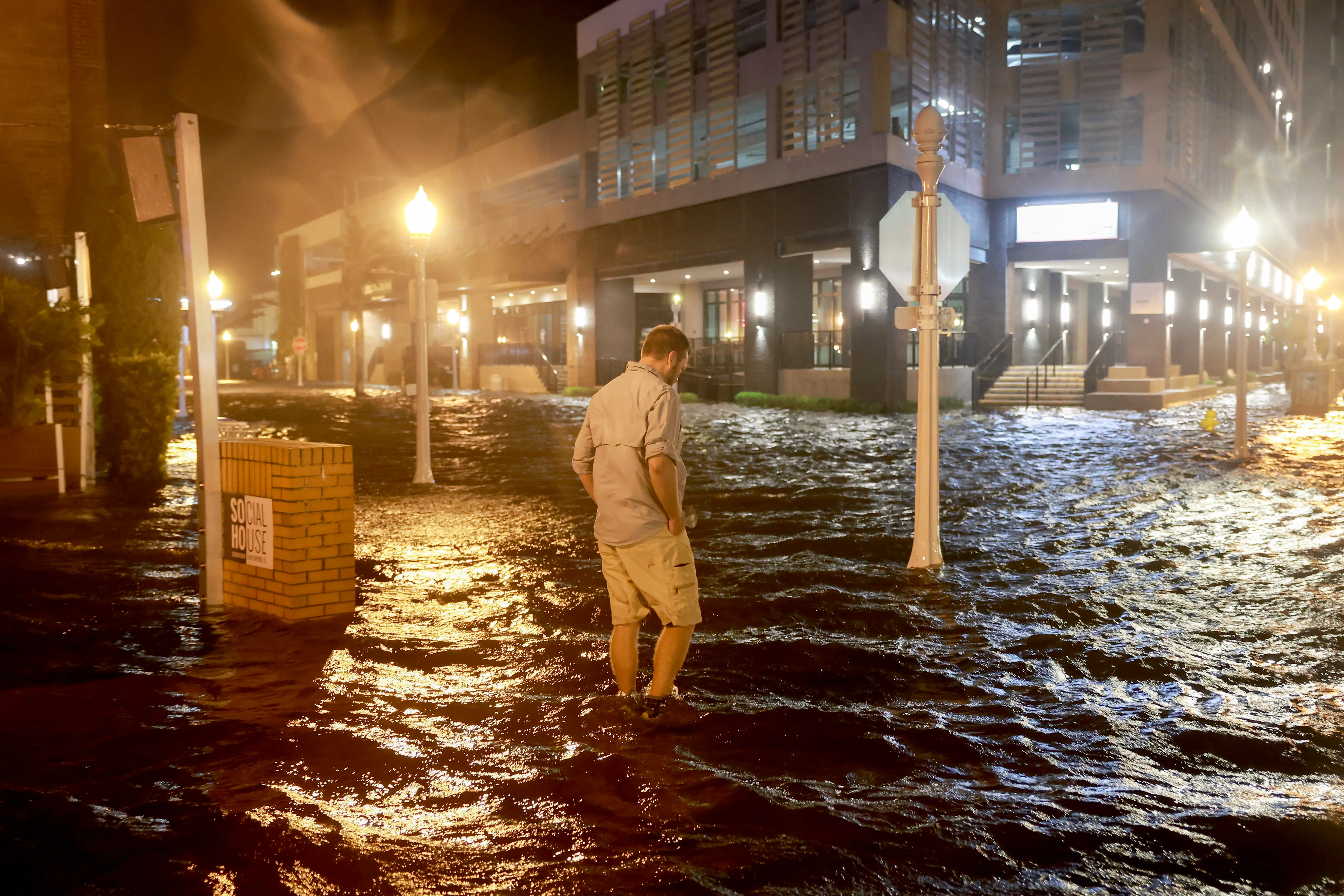 Brandon Marlow walks through surge waters flooding the street after Hurricane Milton came ashore in the Sarasota area on October 09, 2024, in Fort Myers, Florida.