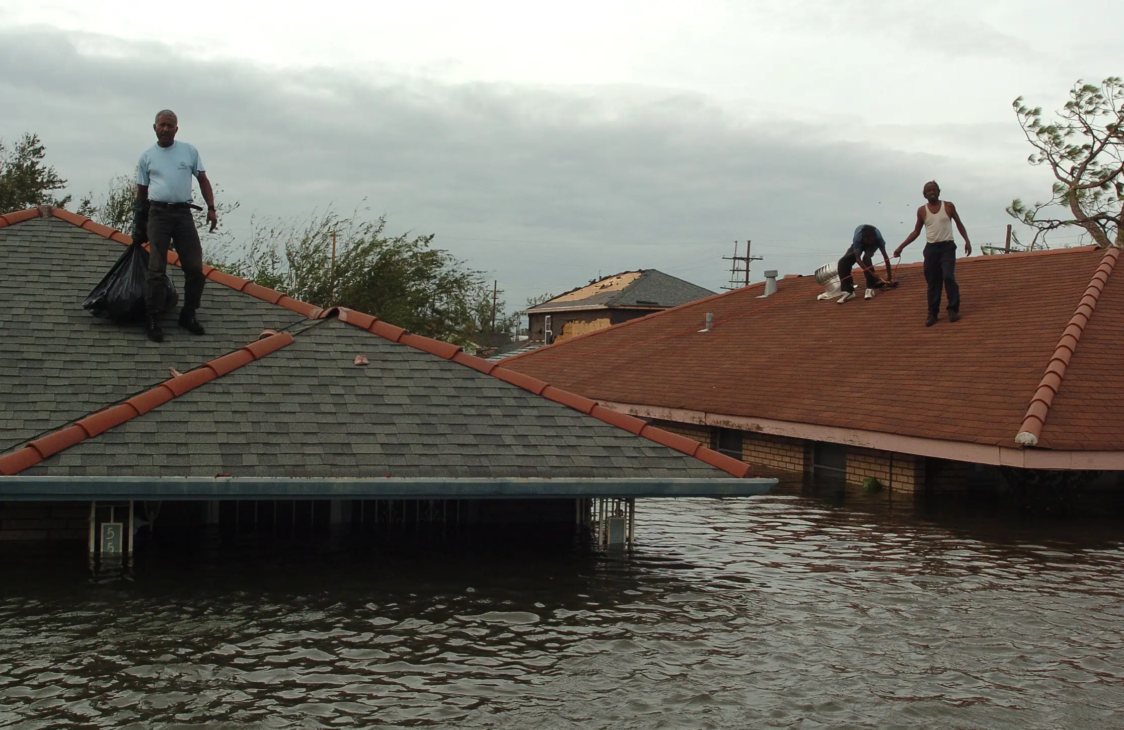 Lower Ninth Ward residents stranded on the roofs wait for a rescue boats in New Orleans, Louisiana on August 29, 2005.