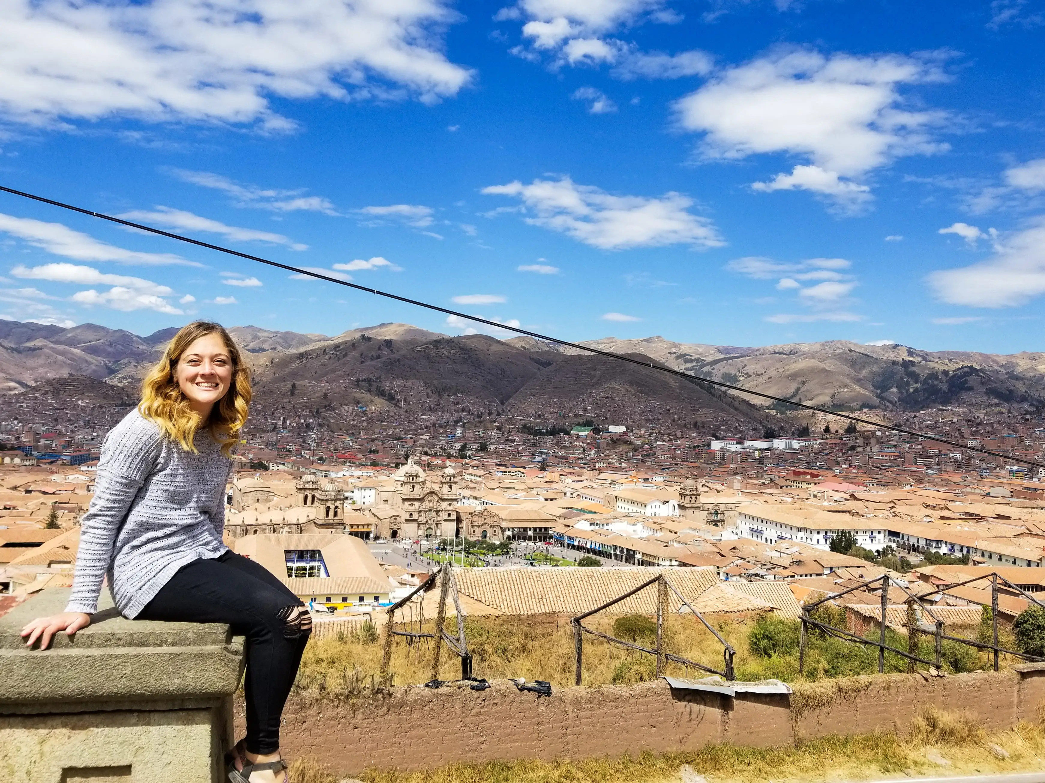 Woman sitting at overlook in Cusco, Peru