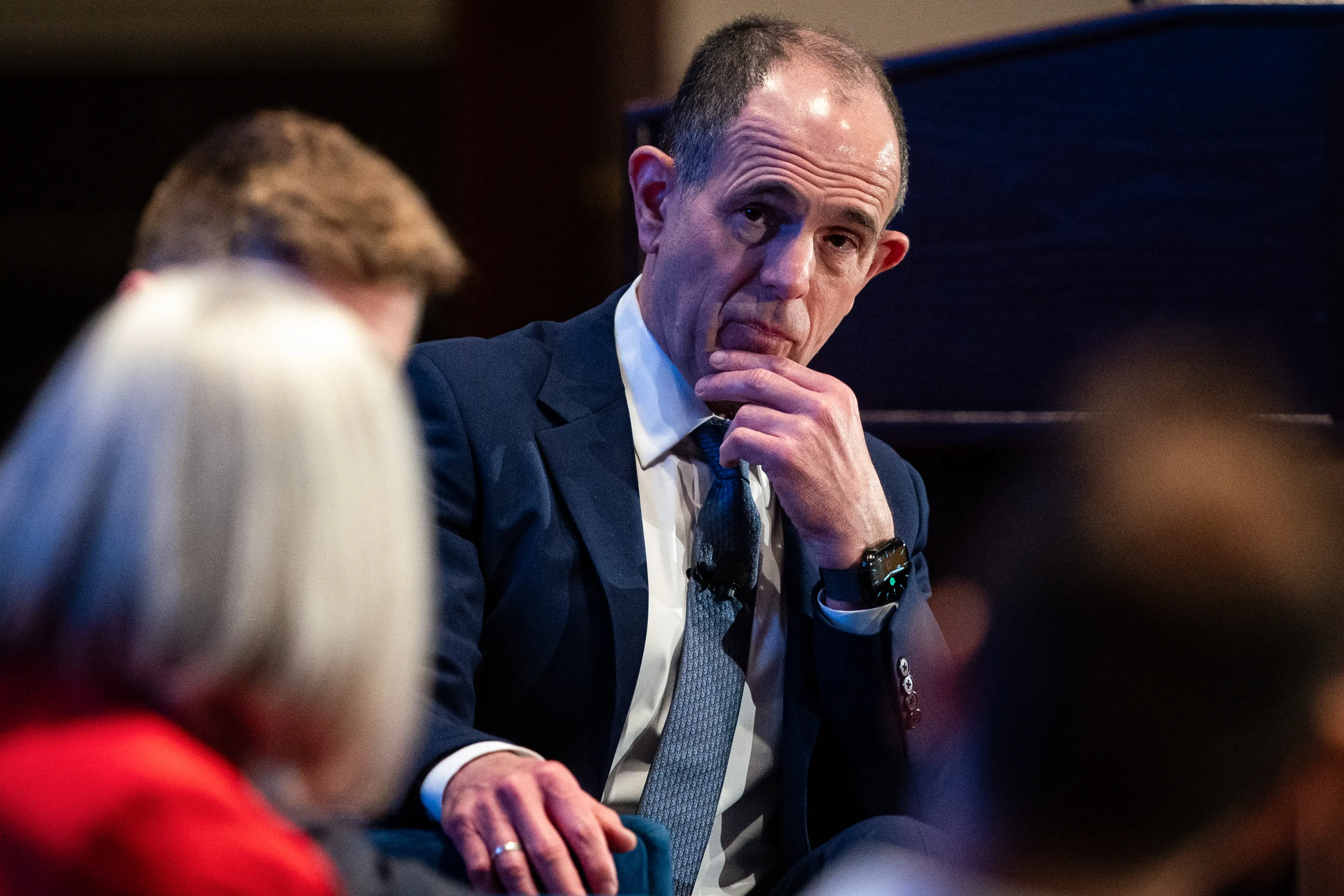 Keith Rabois touches his chin while onstage during an interview. he's wearing a blue suit.