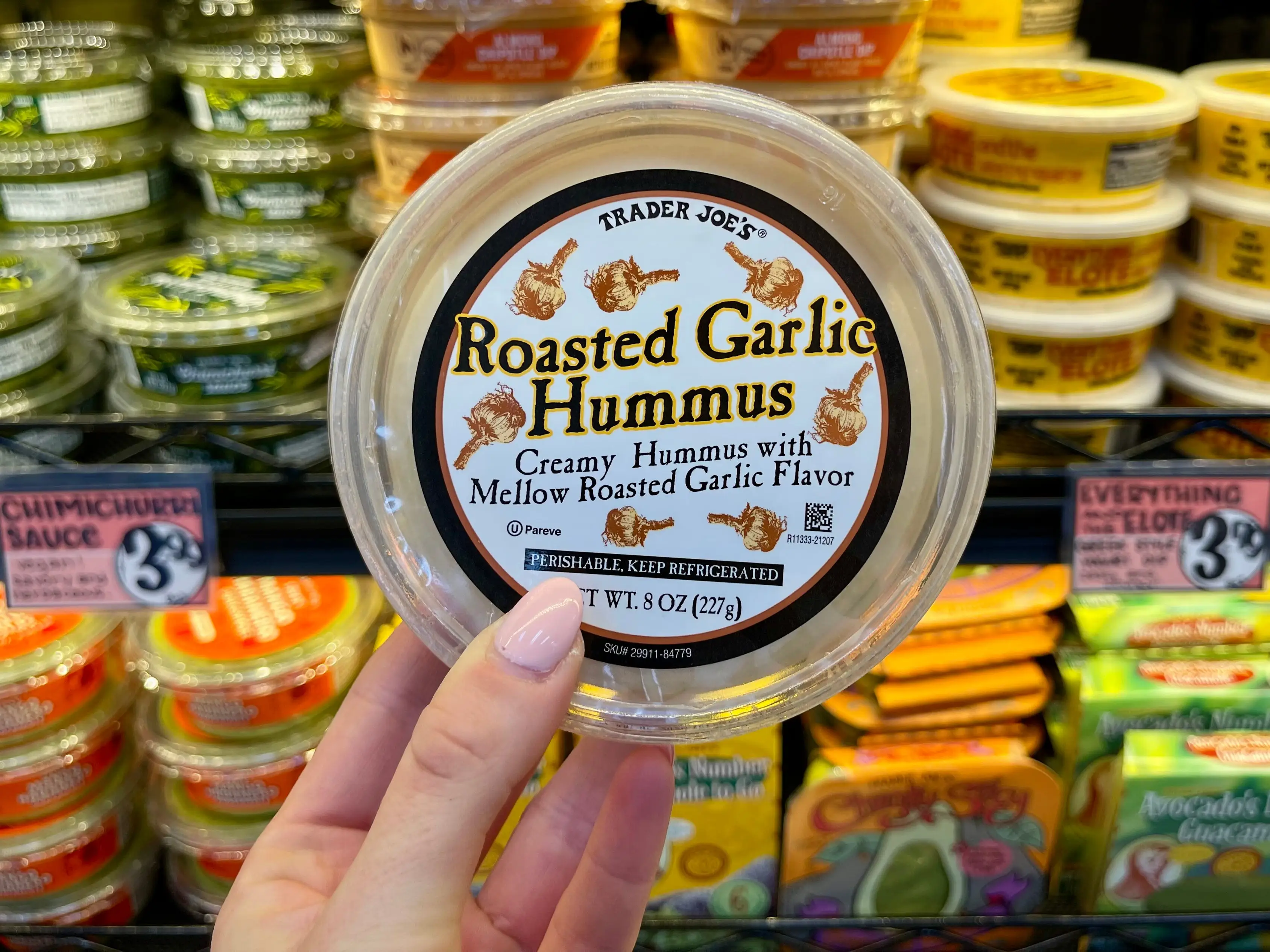 Serena holds a container of Trader Joe's roasted-garlic hummus.