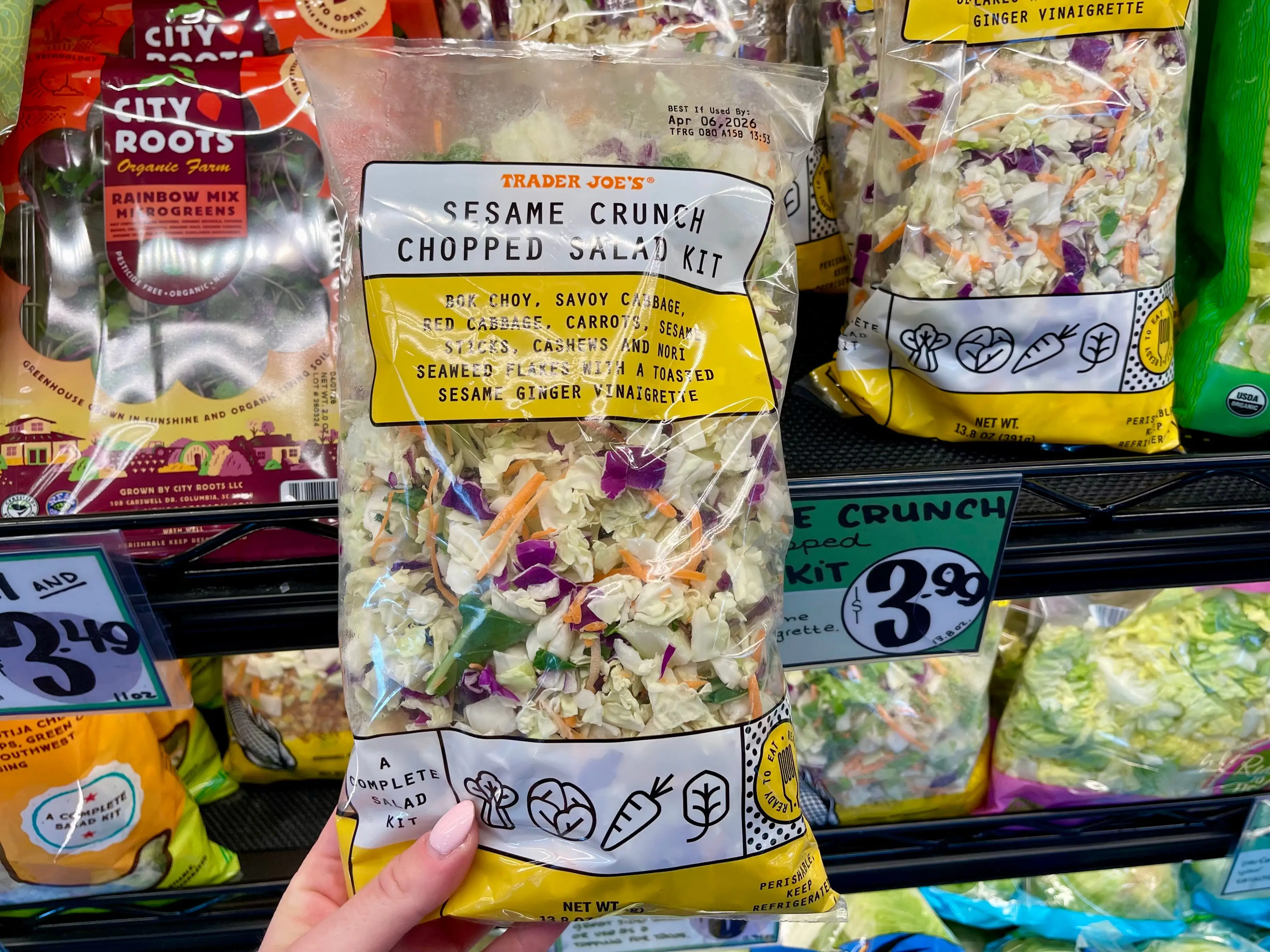 Serena holds a bag of Trader Joe's sesame crunch chopped salad kit.