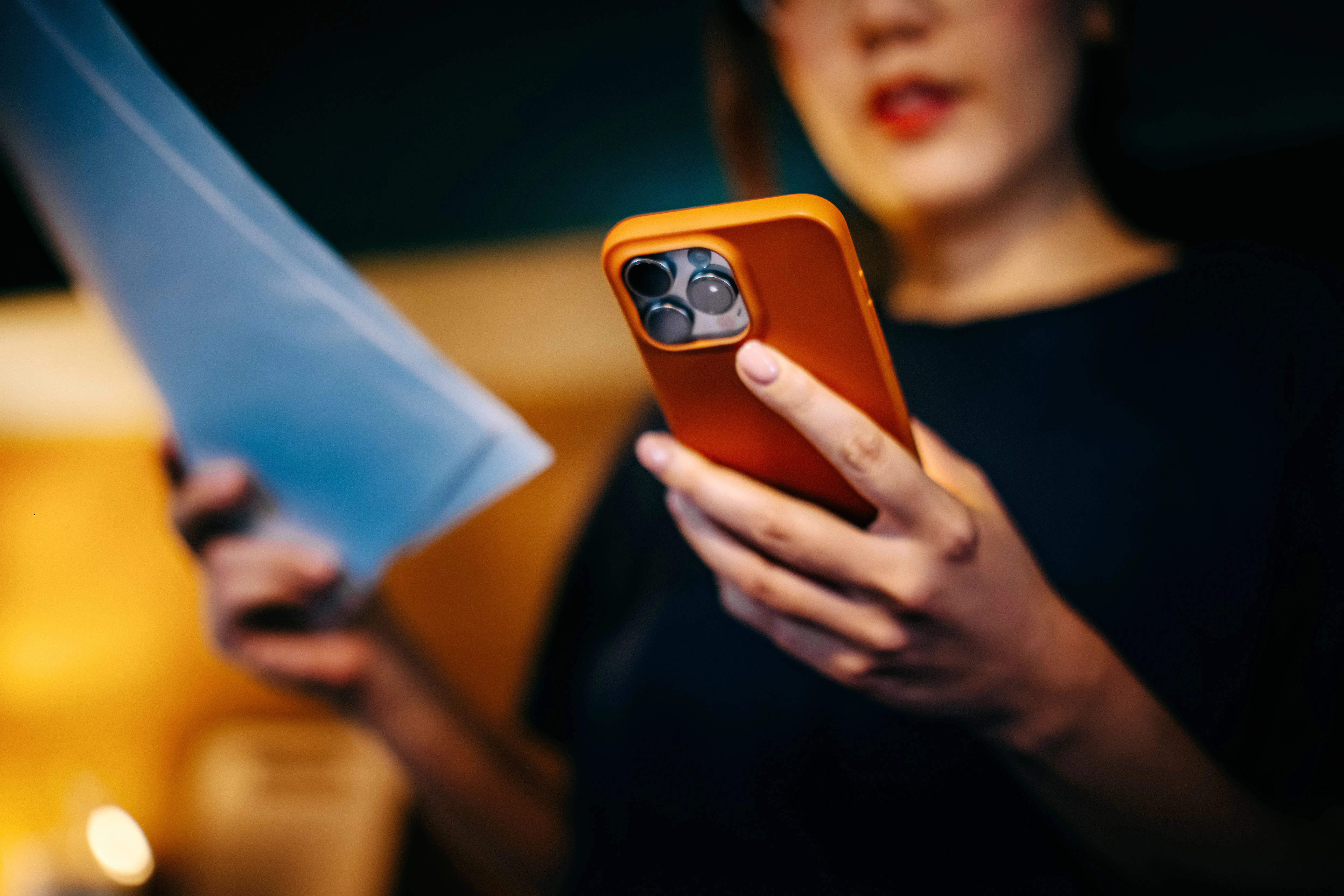 Close-up shot of young Asian woman using her smartphone for scanning the QR code and paying bills from home with e-banking app. Financial technology. Internet banking. Home finances. Managing personal banking and finance at easy access