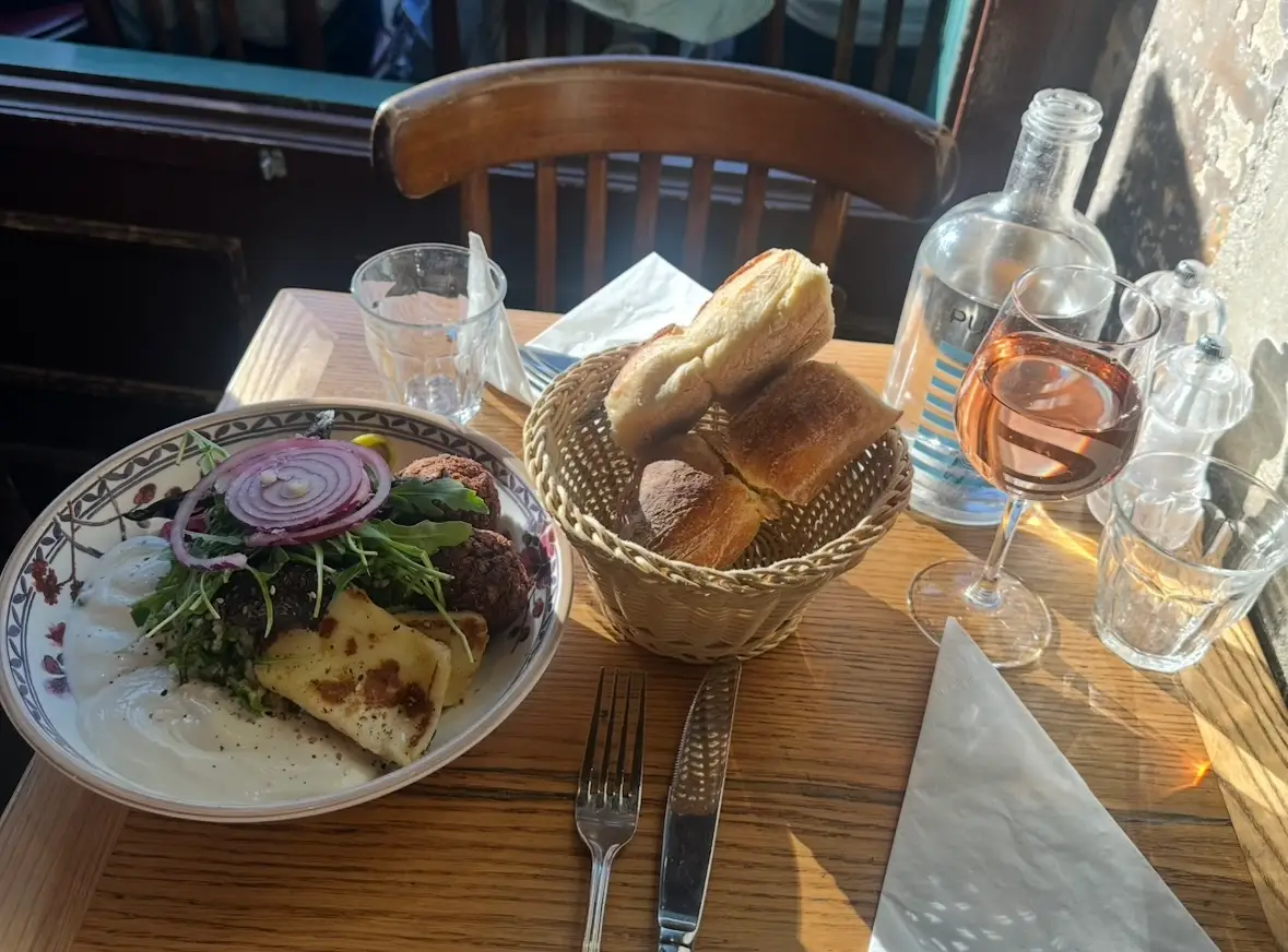 Bread, dinner plate, glass of ewine on table