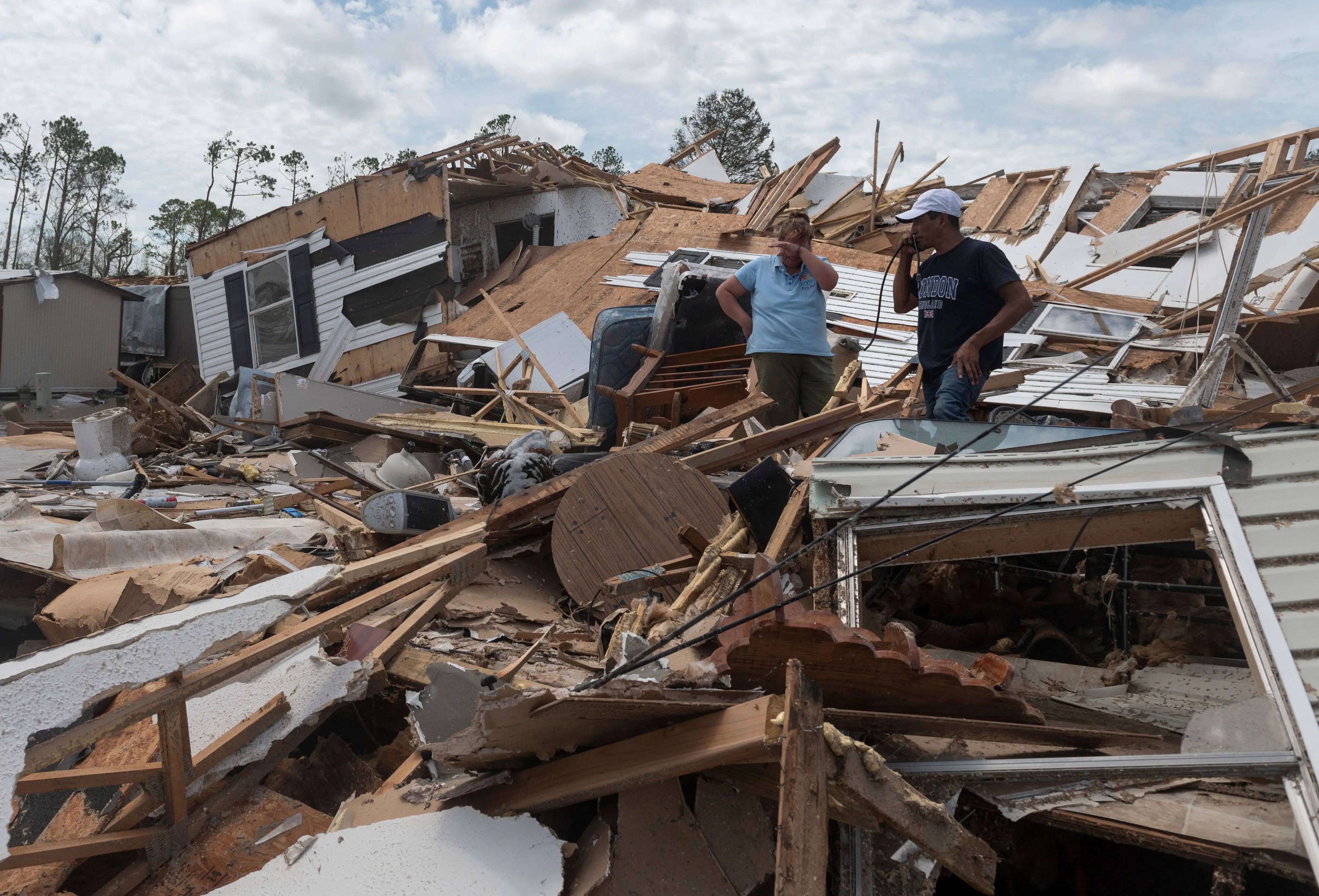 A couple react as they go through their destroyed mobile home following the passing of hurricane Laura in Lake Charles, Louisiana, on August 27, 2020