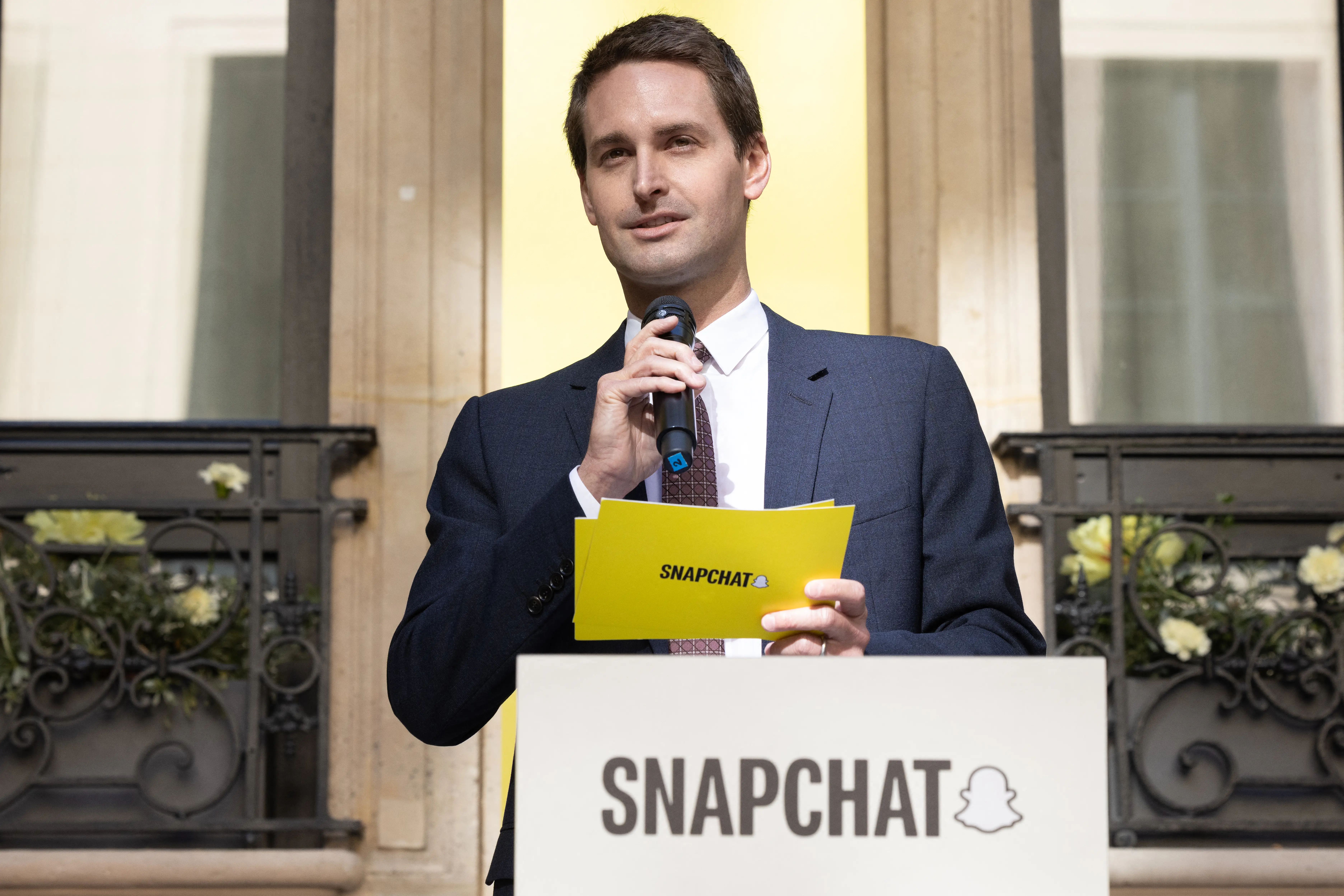 Snap CEO Evan Spiegel speaks into a microphone