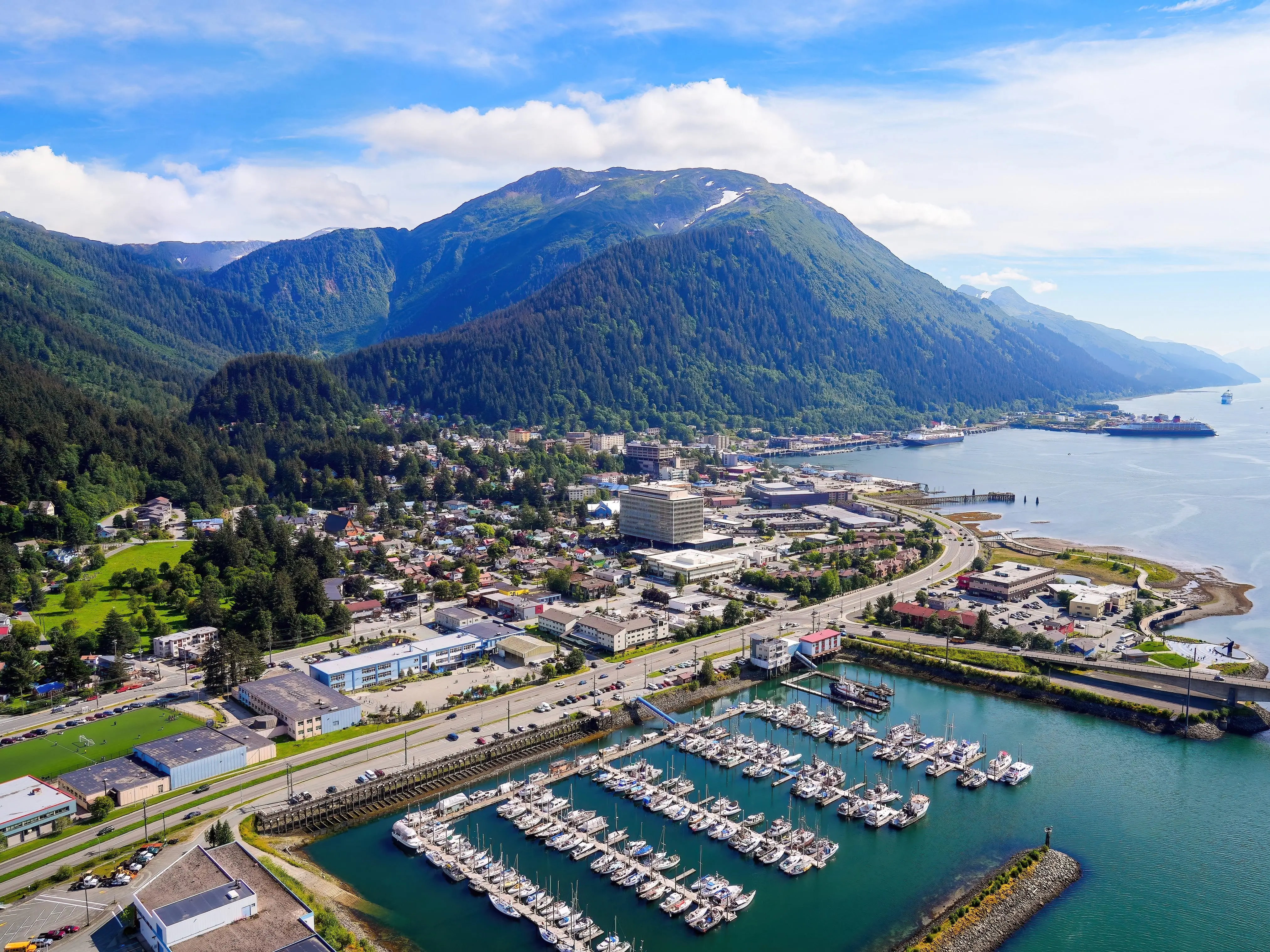 Aerial view of the downtown Juneau, the state capital of Alaska, USA, along the Gastineau Channel in the Arctic - Harris Harbor towered by Alaskan summits next to Douglas Bridge