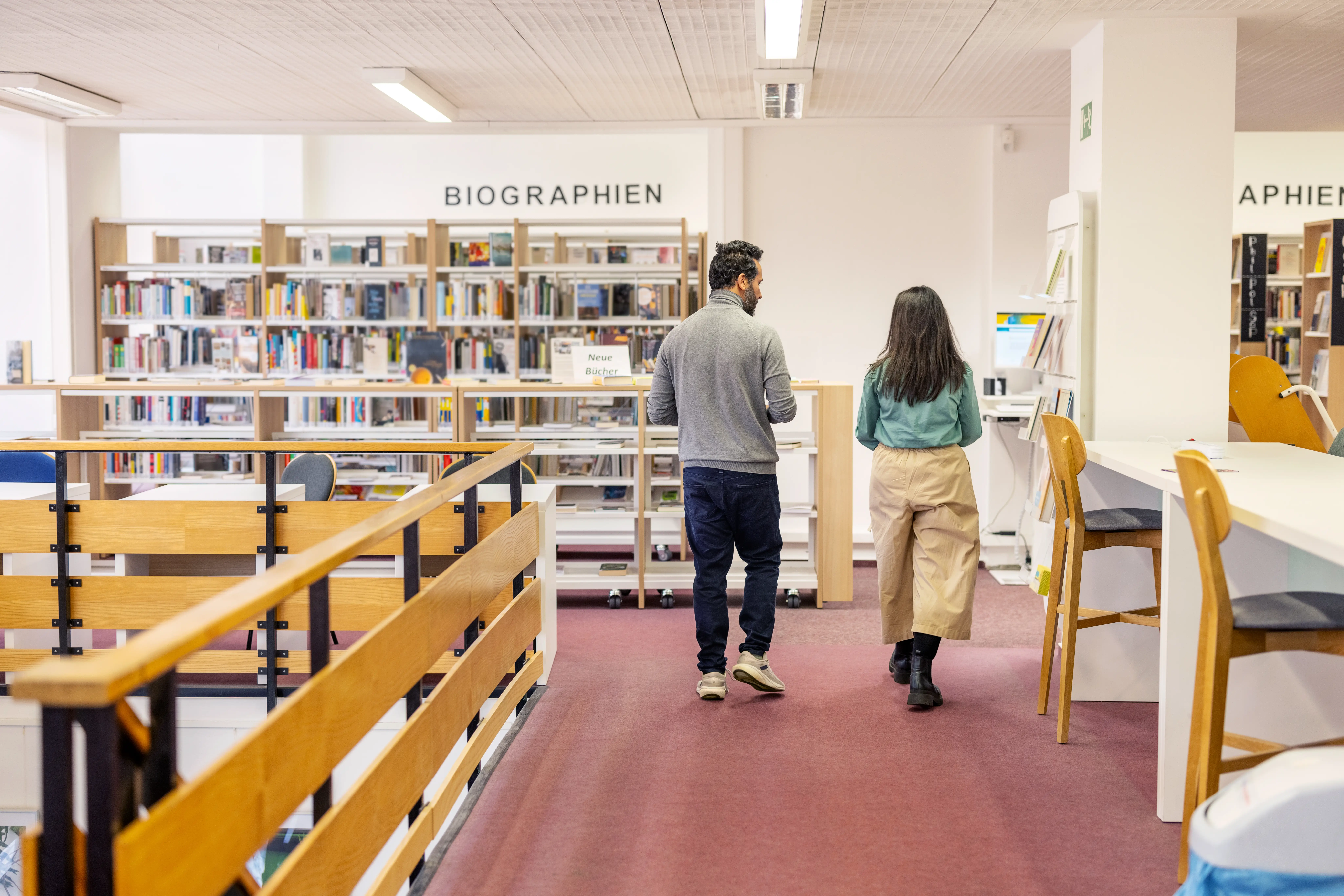 Two people walking in German library