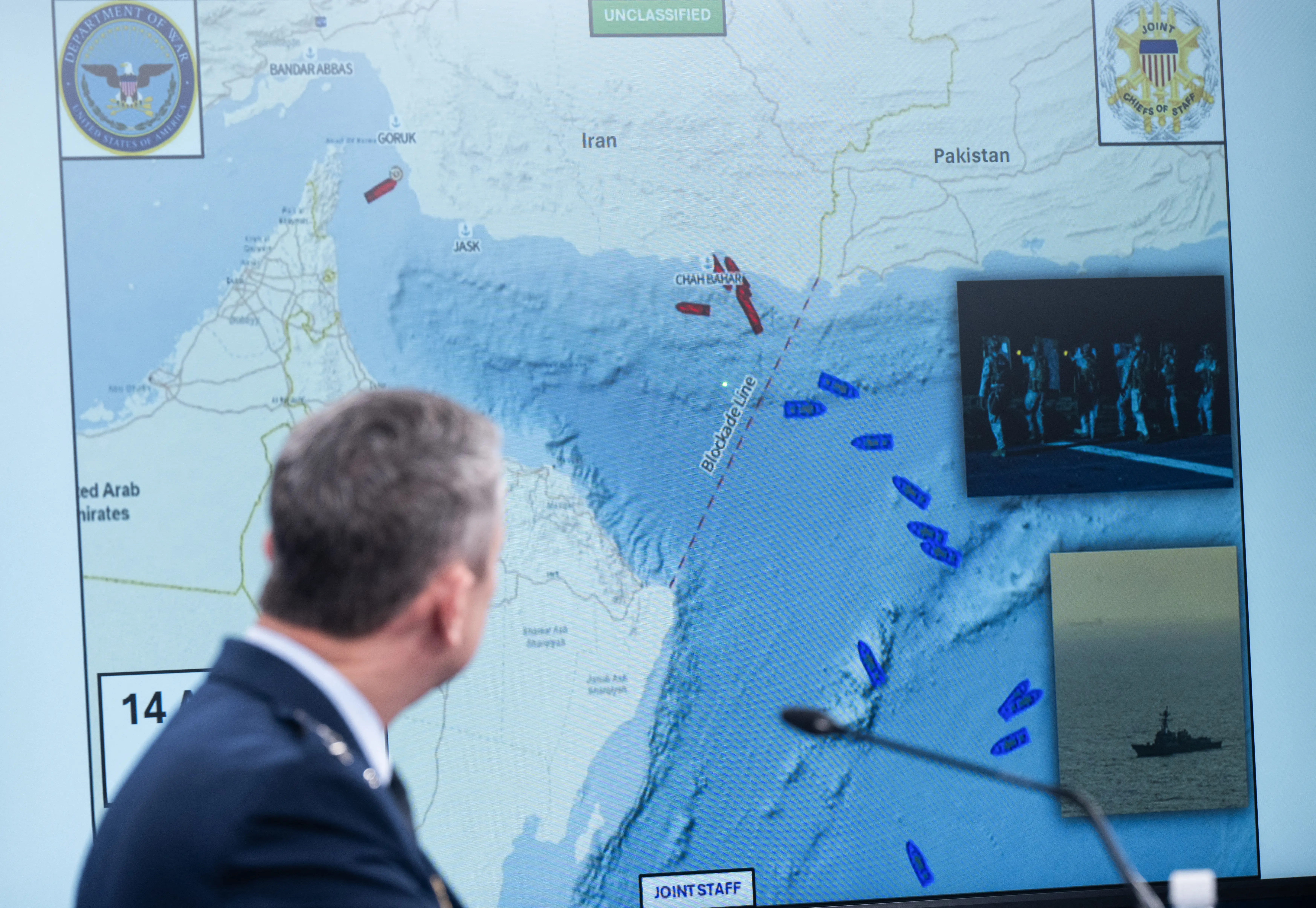 A man stands in front of a map showing Iran and surrounding waters.