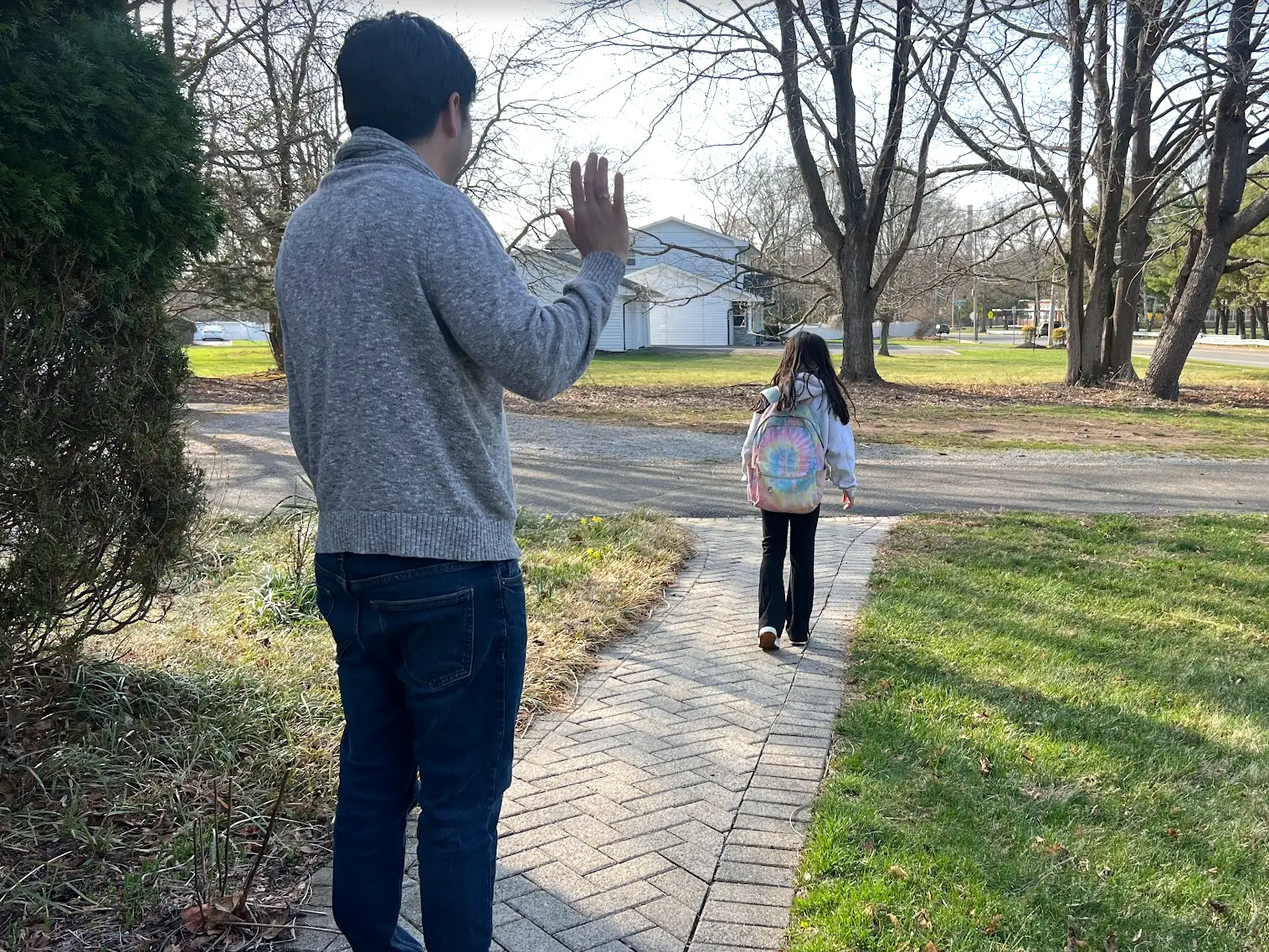 José R. Mendoza waving goddbye to his daughter as she walks to school alone