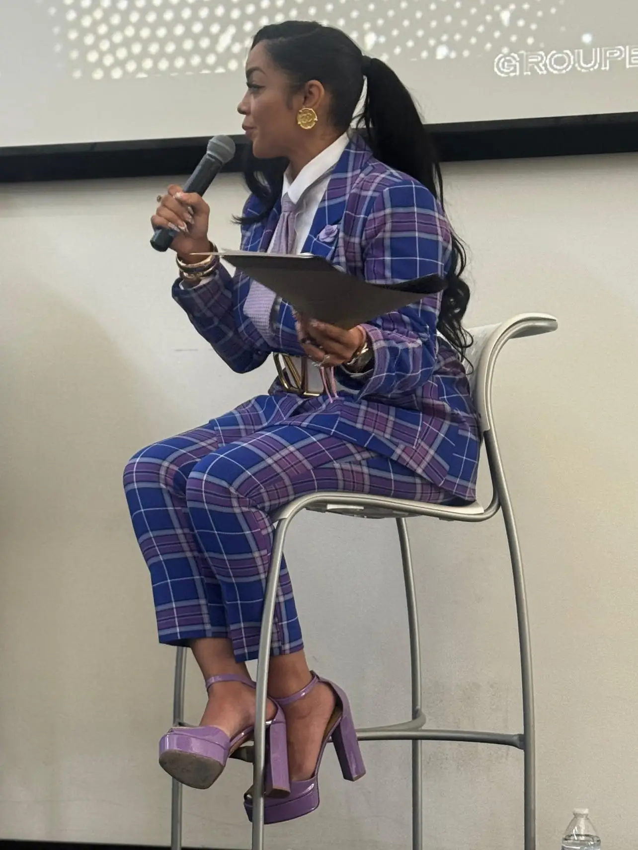 Crystal Foote speaking onstage while holding a microphone.