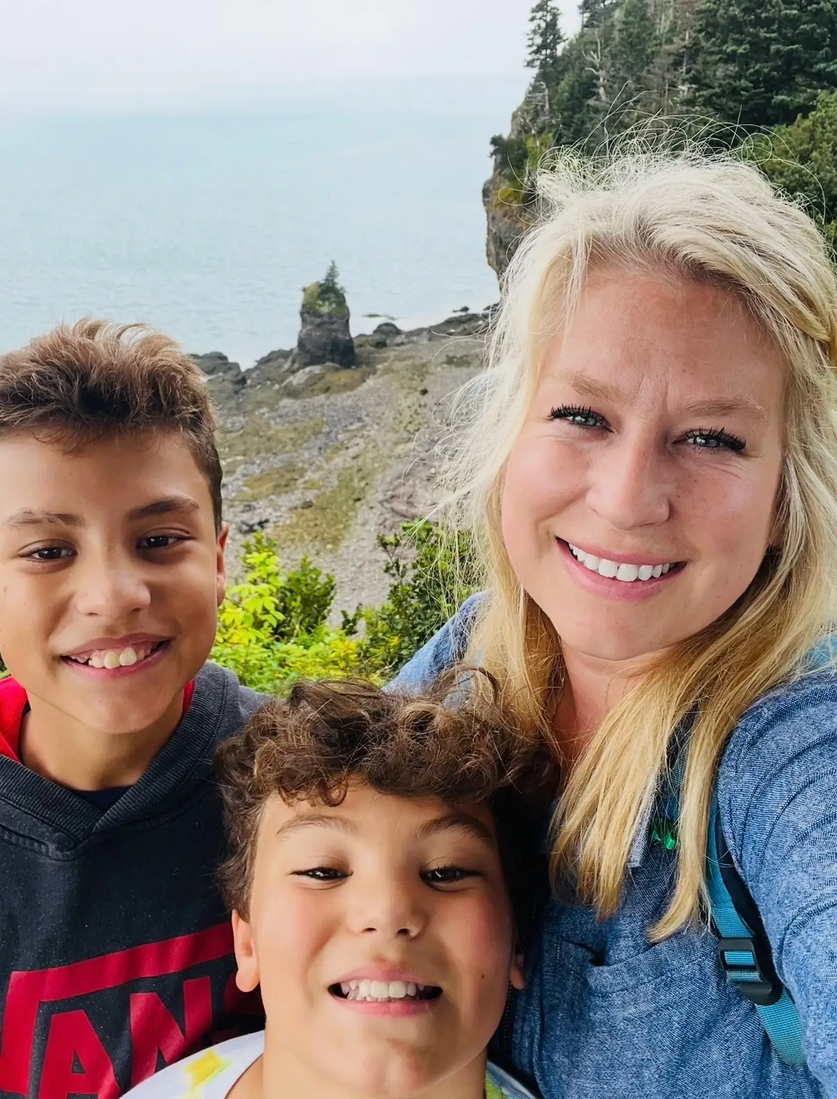 Mandy Castillo, owner of Prigel Family Creamery, smiles with her children near water.