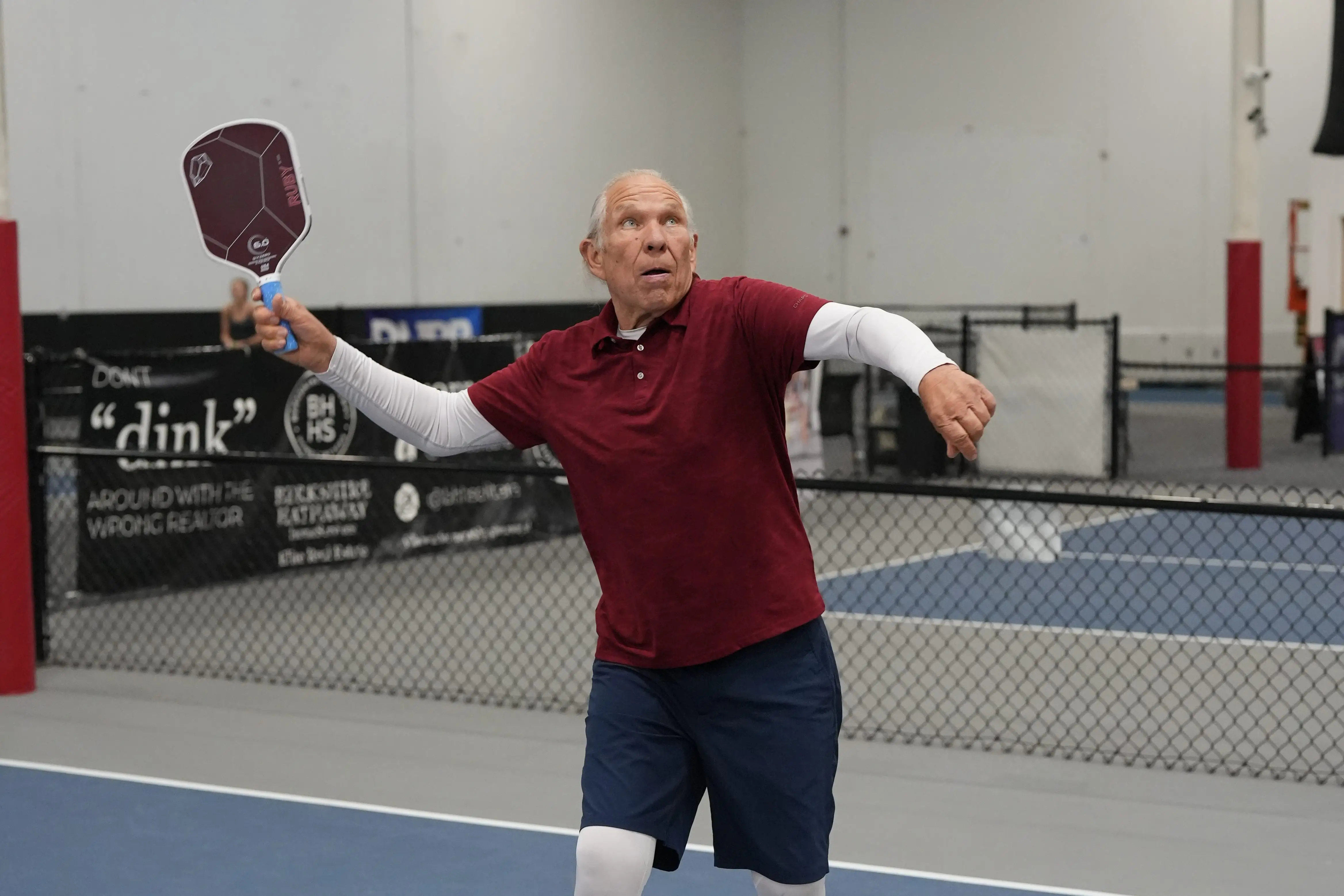 A man swinging his pickleball paddle.
