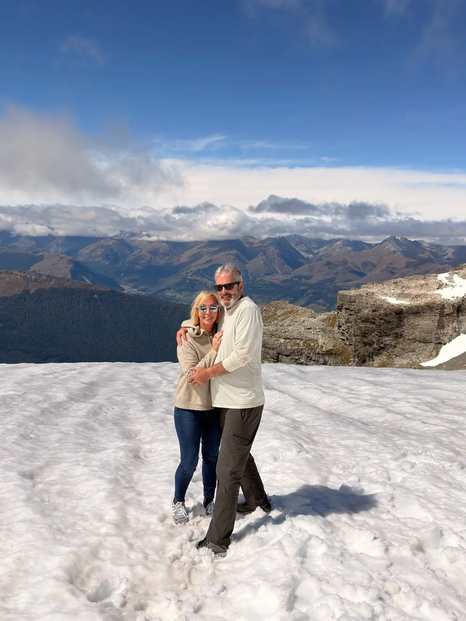 Couple on a snowfield near Earnslaw Burn in New Zealand's South Island.
