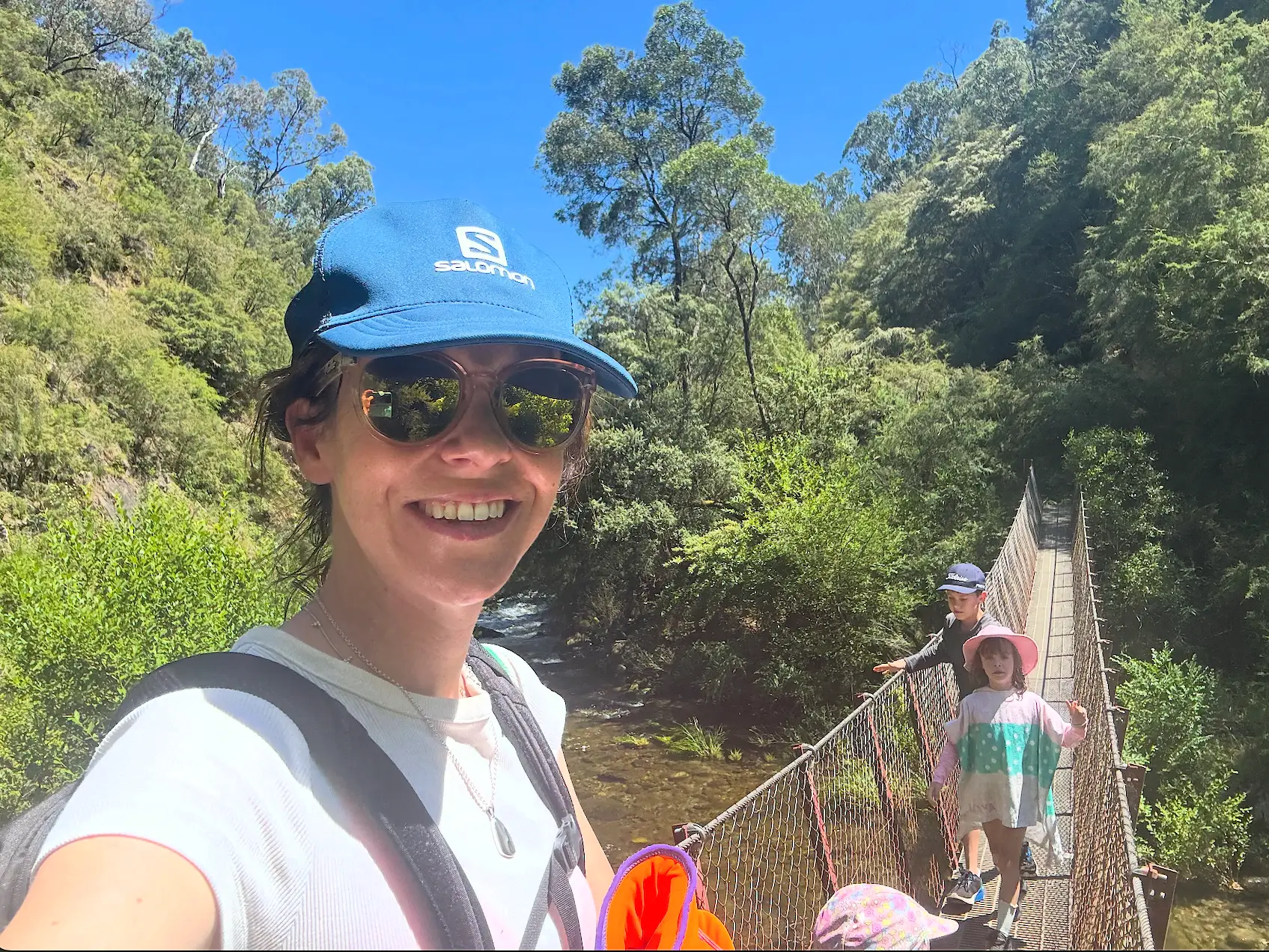the author wearing a hat and sunglasses on a hike with her kids