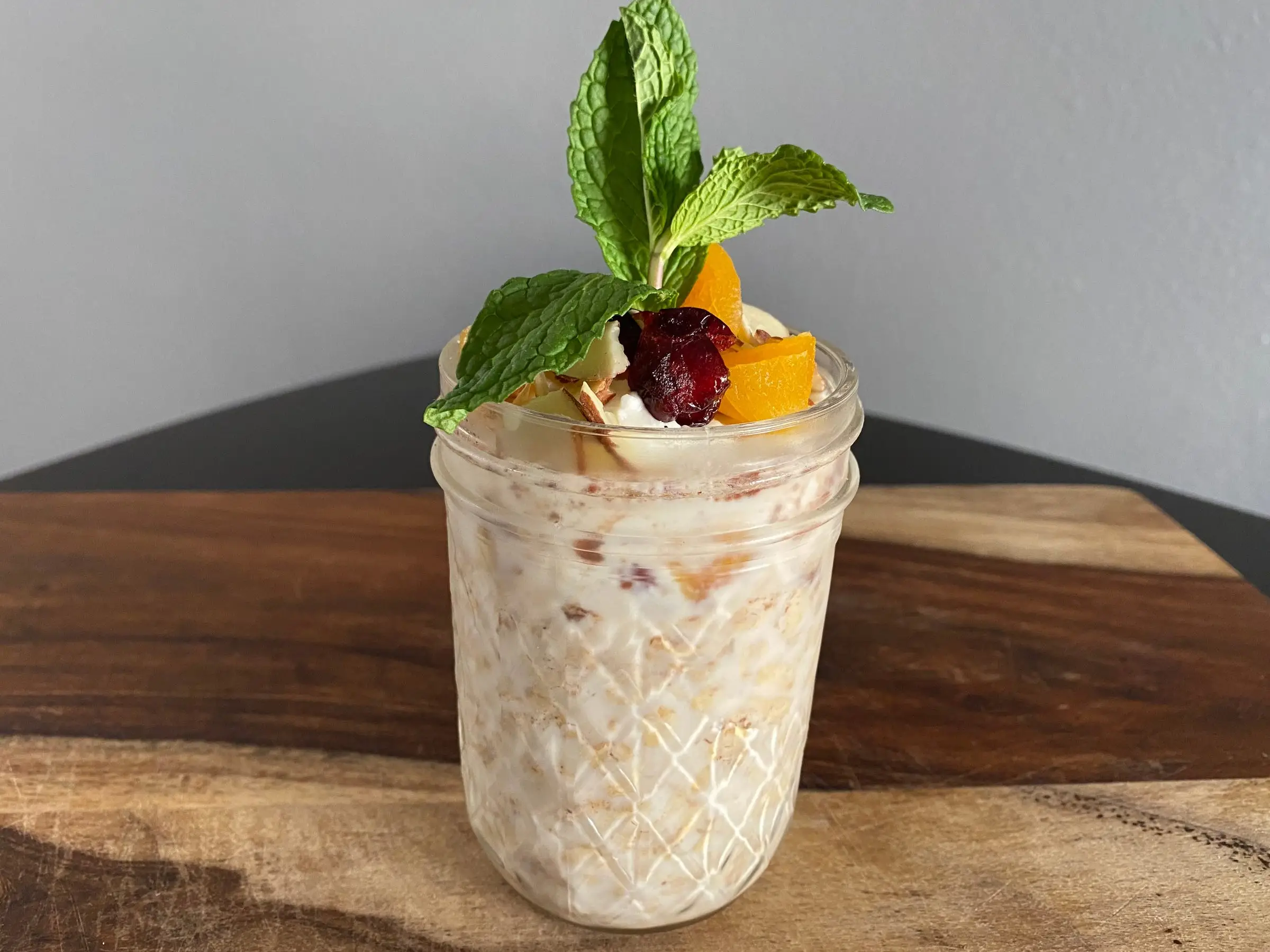 Overnight oats in mason jar with nuts, mint on top