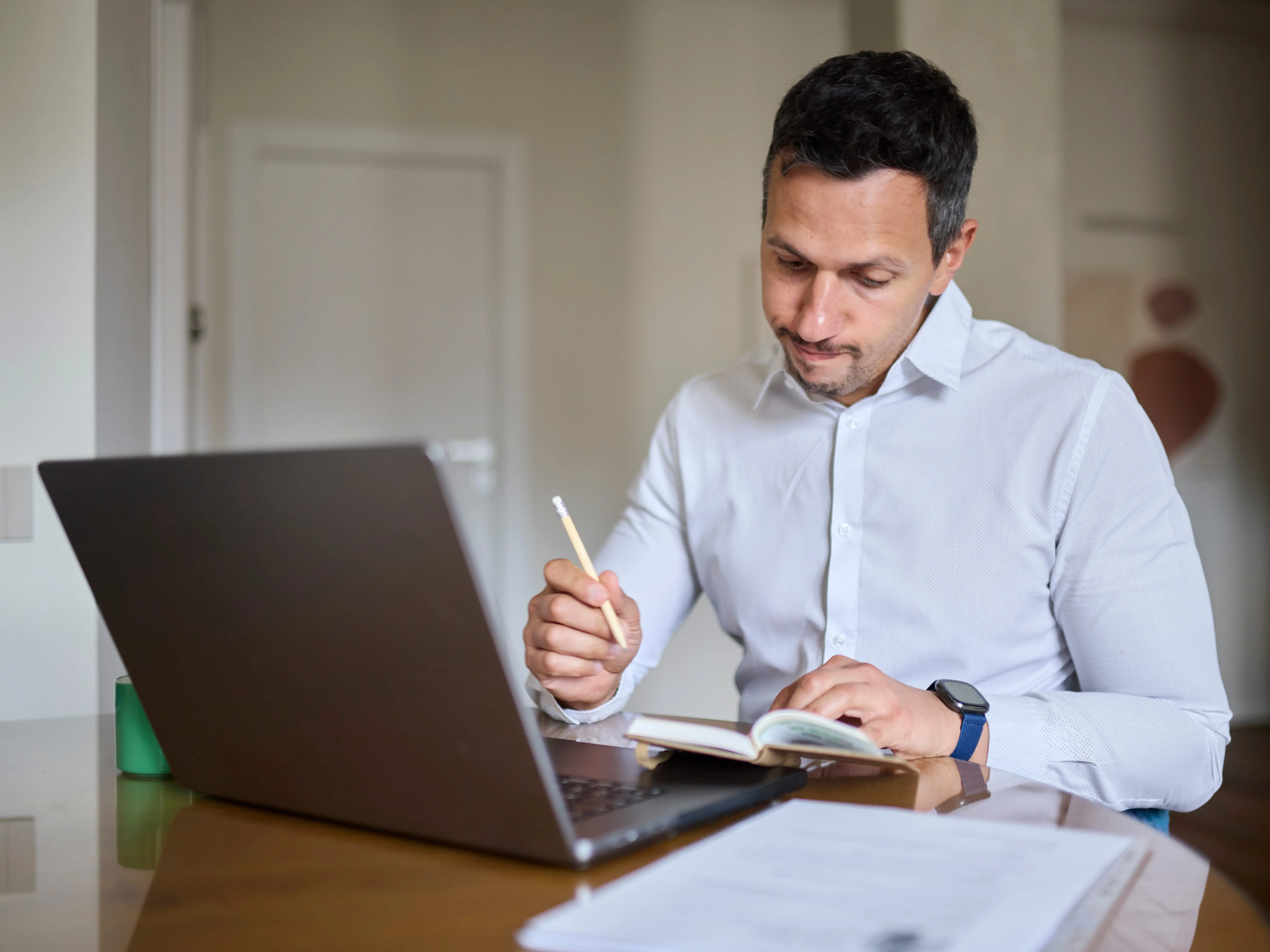 a man looking at this laptop and notebook