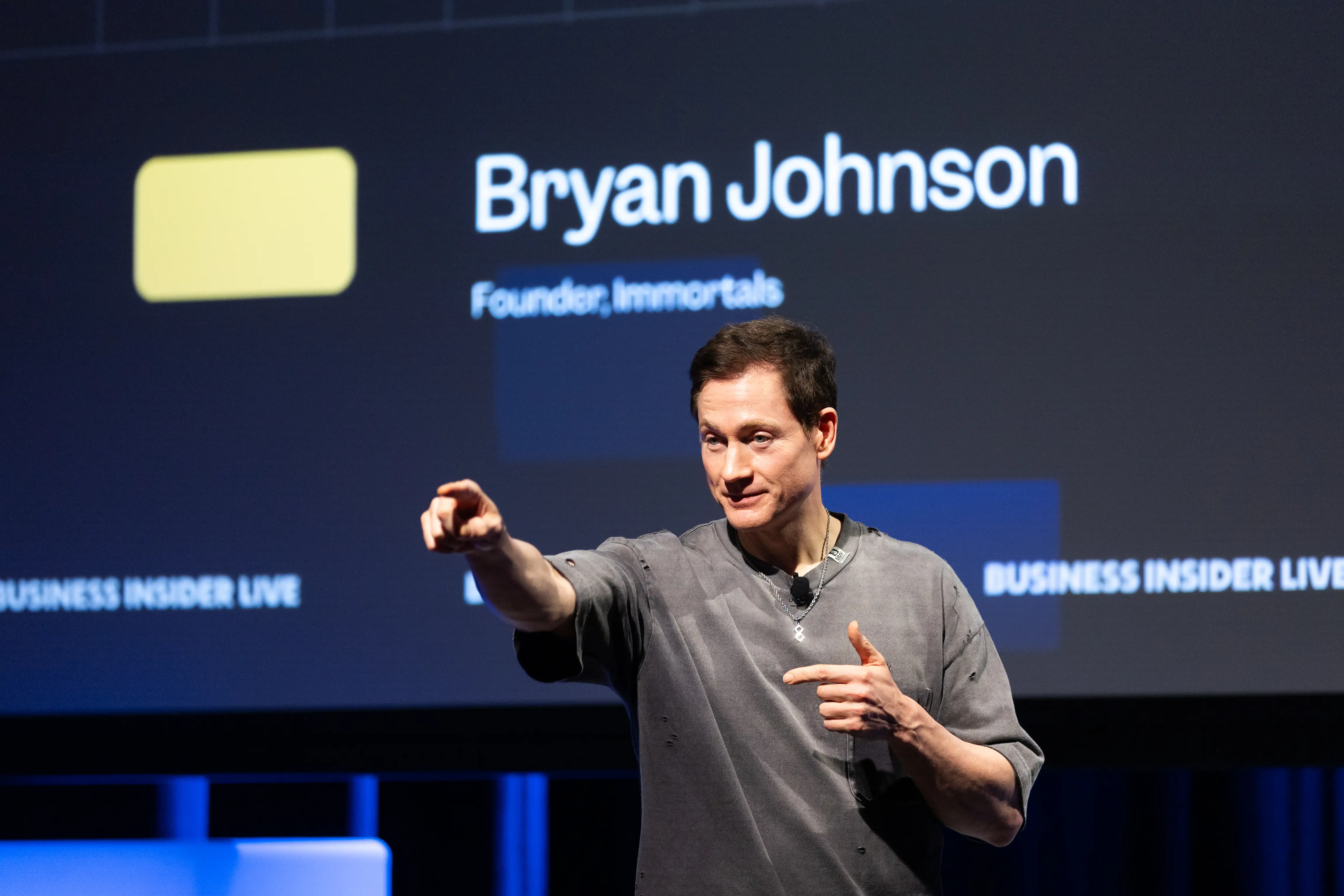 Bryan Johnson onstage pointing his finger into the audience.